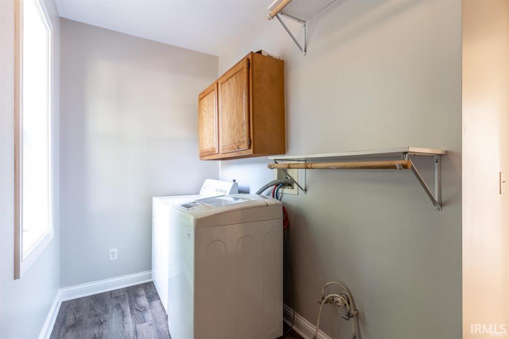 Laundry area featuring cabinet space, dark wood-style floors, and washing machine and clothes dryer