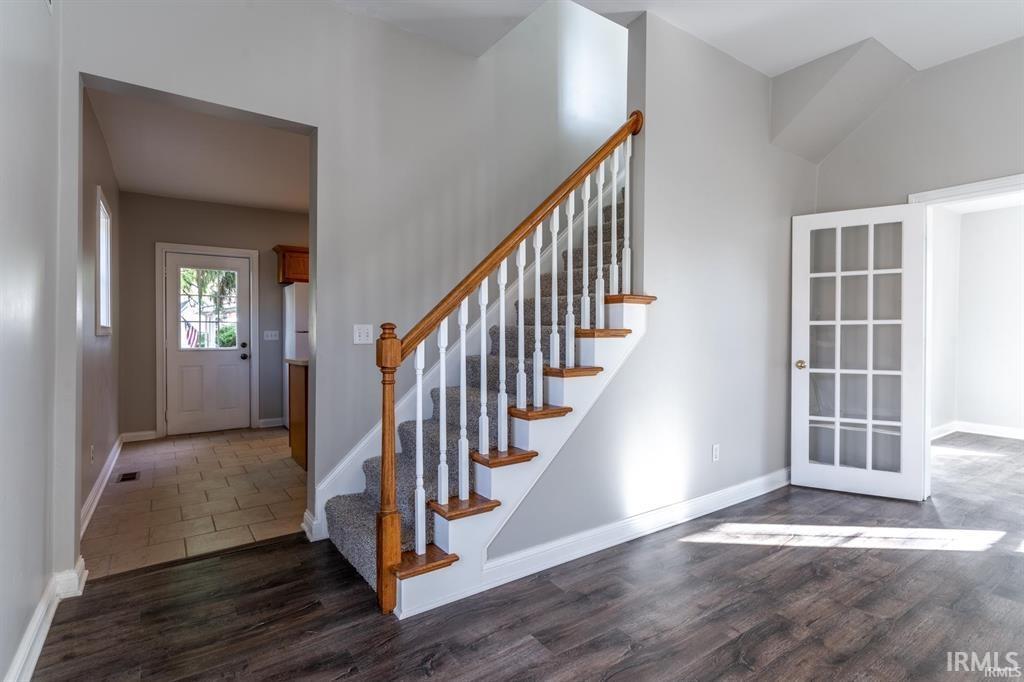 Foyer with stairway and dark wood-type flooring
