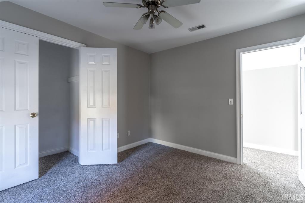 Unfurnished bedroom with carpet flooring and a ceiling fan