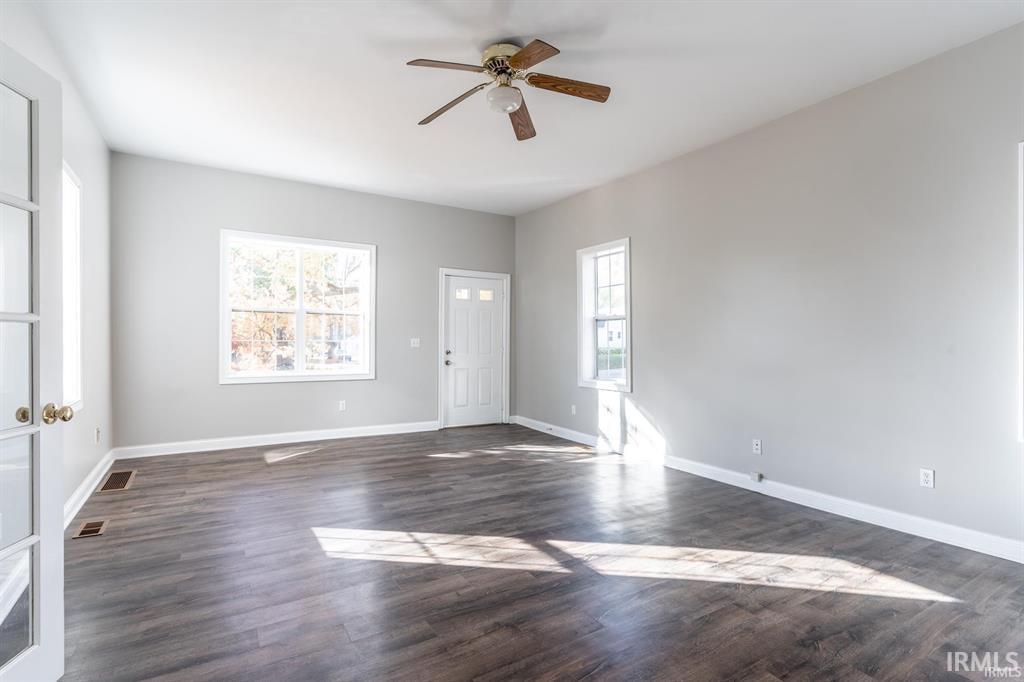 Entryway featuring a ceiling fan, plenty of natural light, and dark wood-style floors