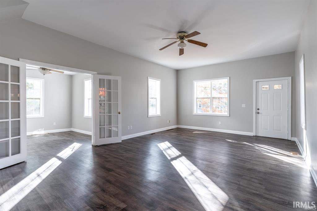 Foyer featuring ceiling fan, healthy amount of natural light, french doors, and dark wood-style flooring
