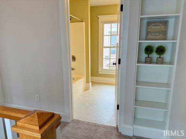 Hall featuring carpet floors and built-in shelving