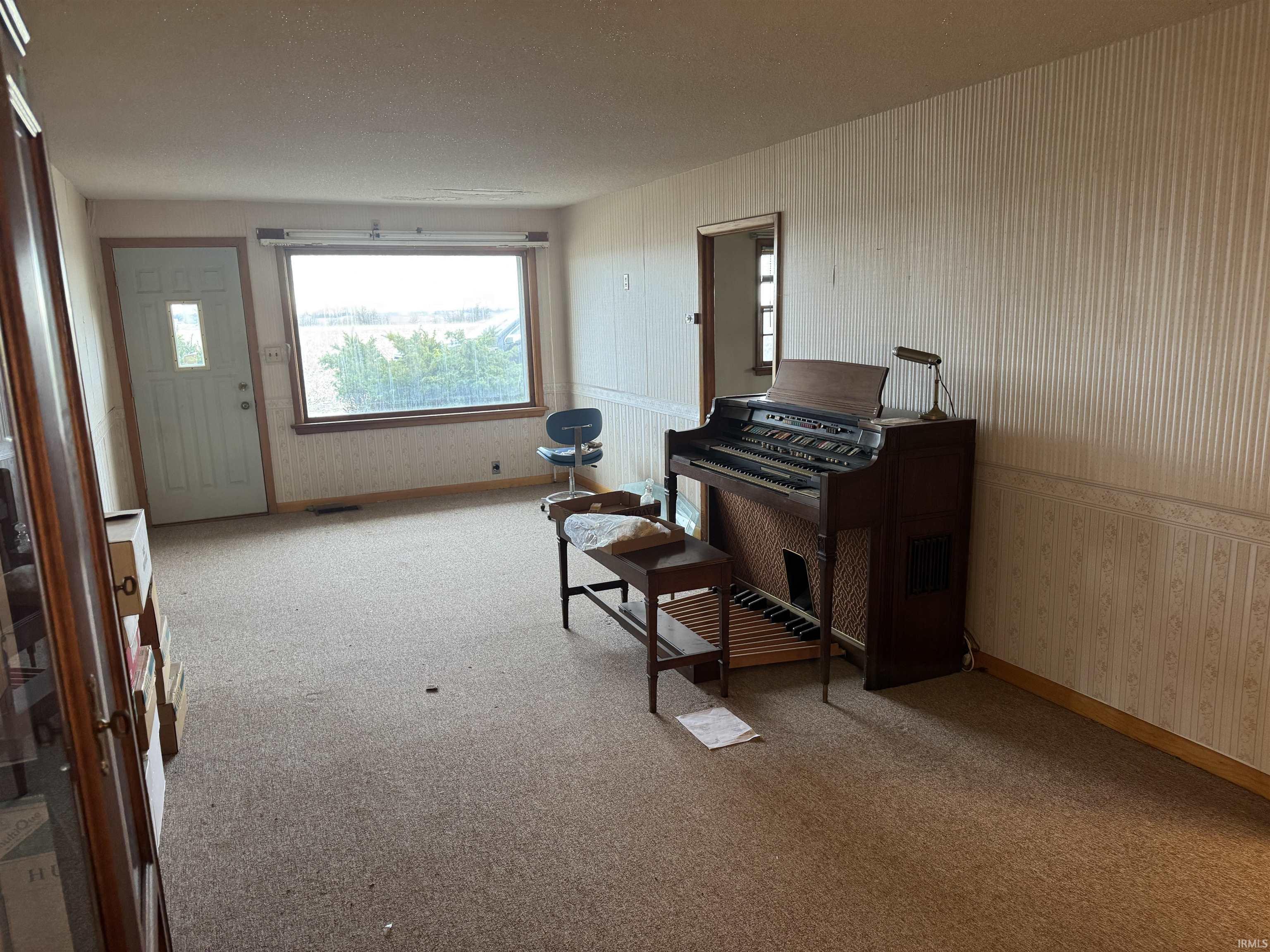 Sitting room featuring wallpapered walls and light carpet