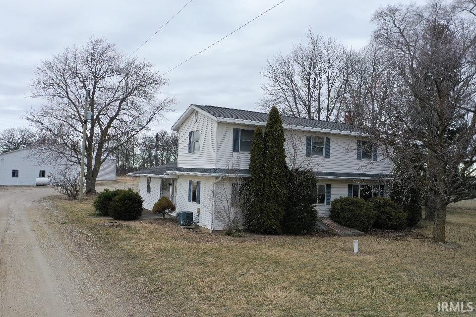 Traditional-style house with a metal roof, a front yard, and a chimney