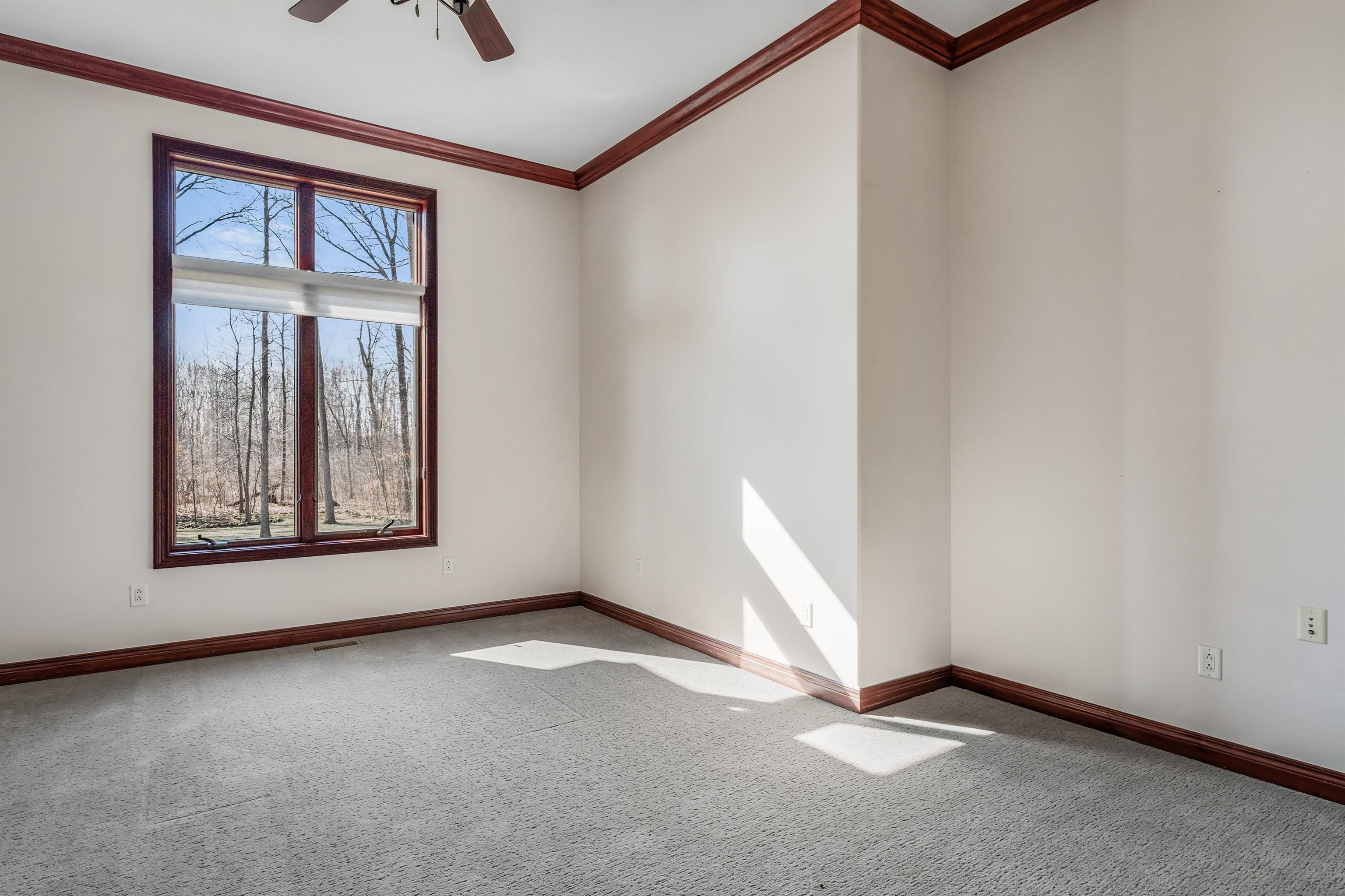 Spare room with ornamental molding, light carpet, and ceiling fan