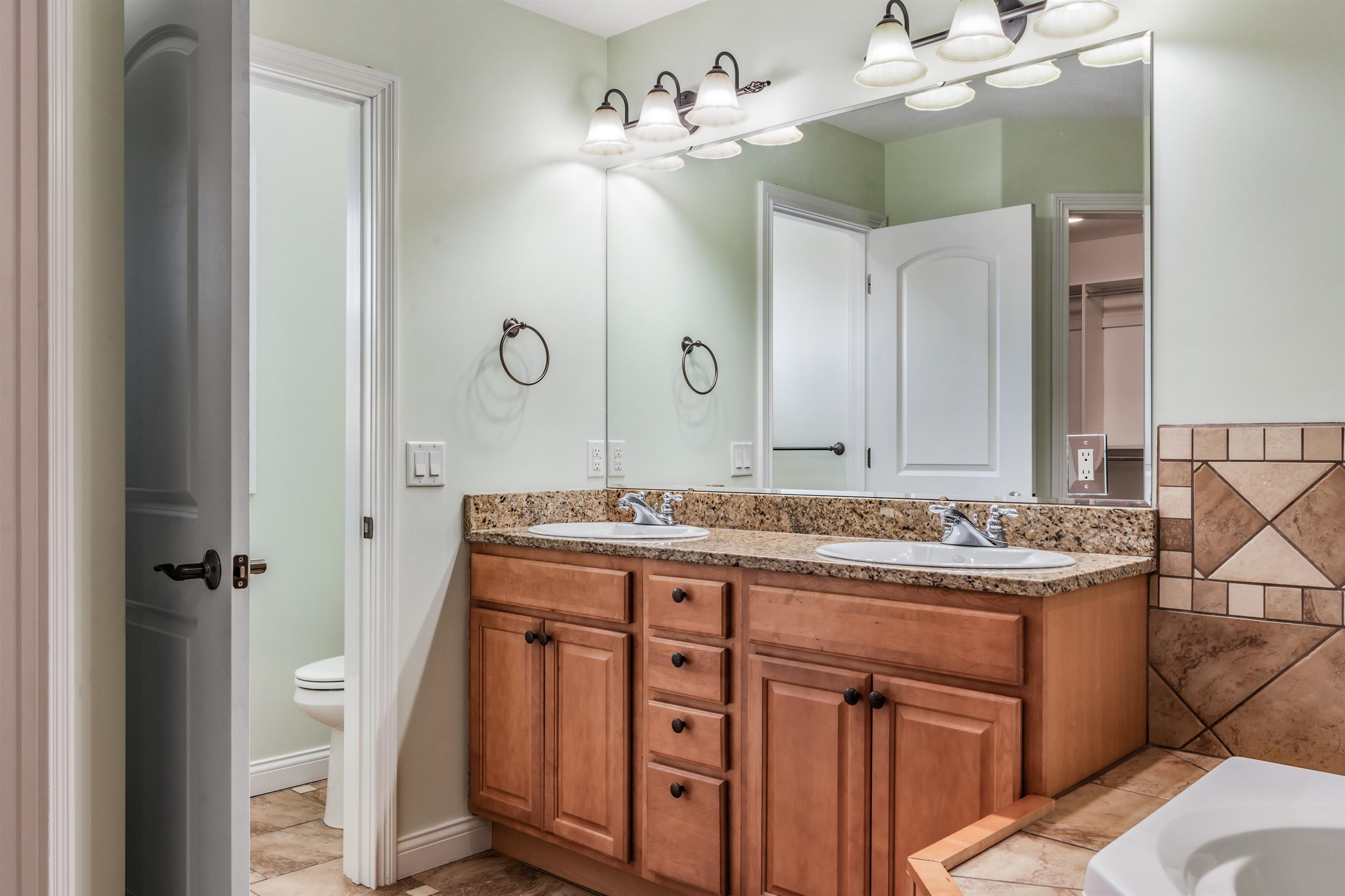 Full bath featuring double vanity and a bath