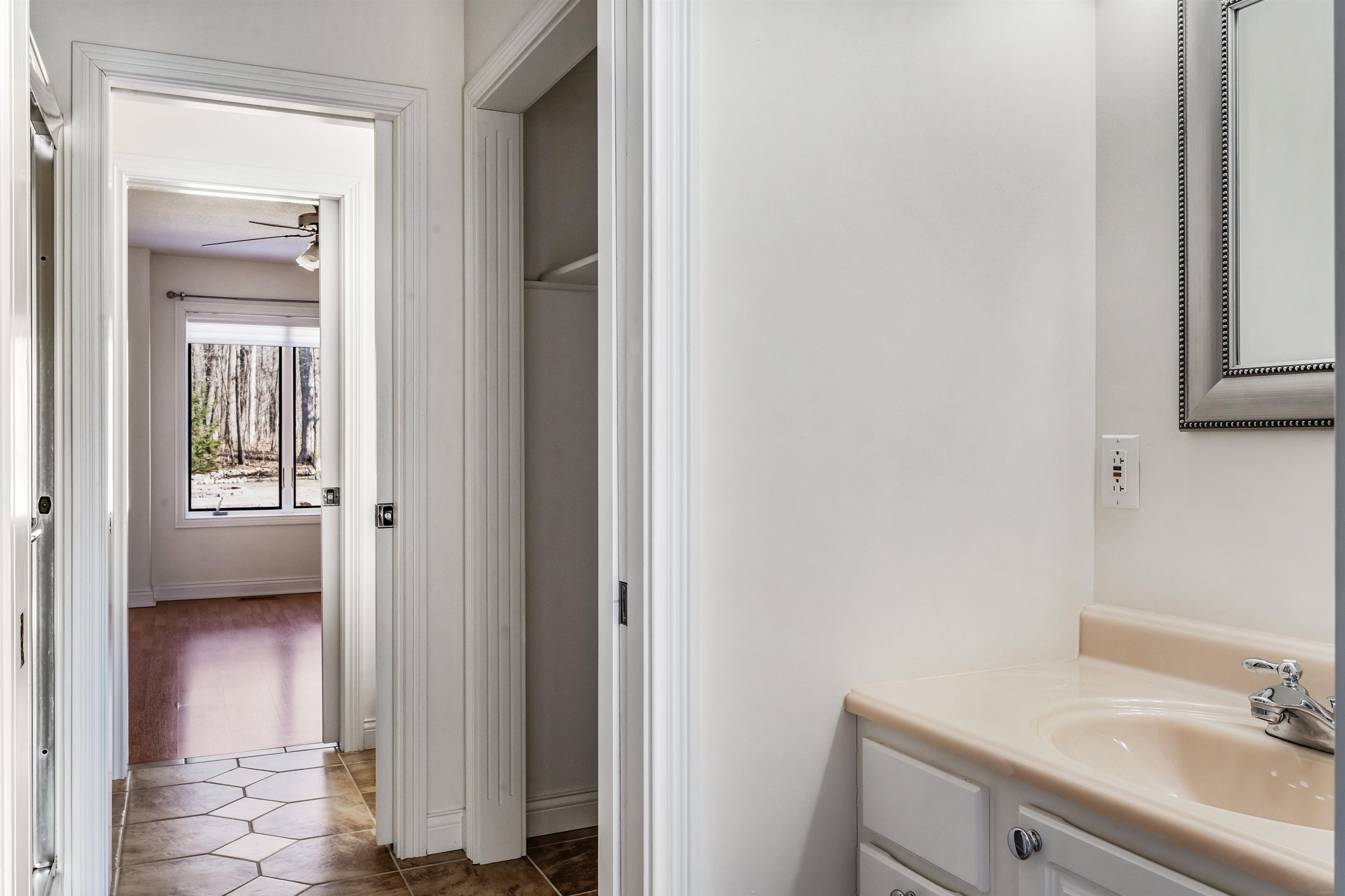 Bathroom with vanity, a ceiling fan, and dark tile patterned floors