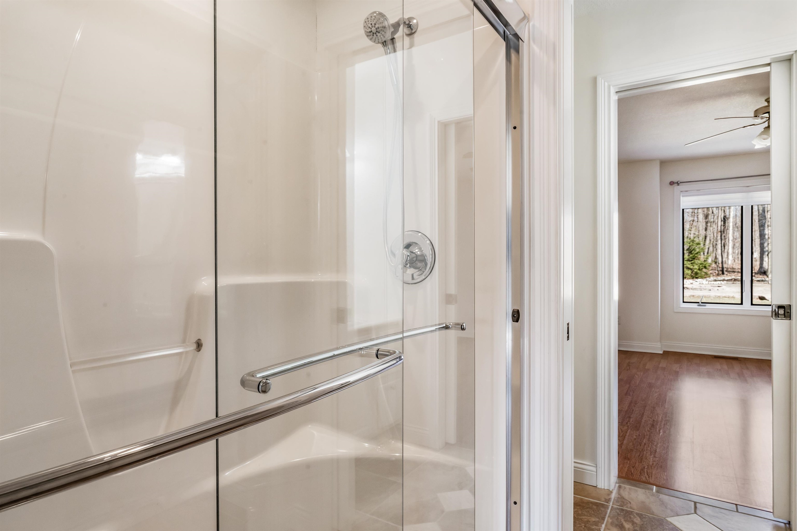 Bathroom featuring a stall shower and a ceiling fan