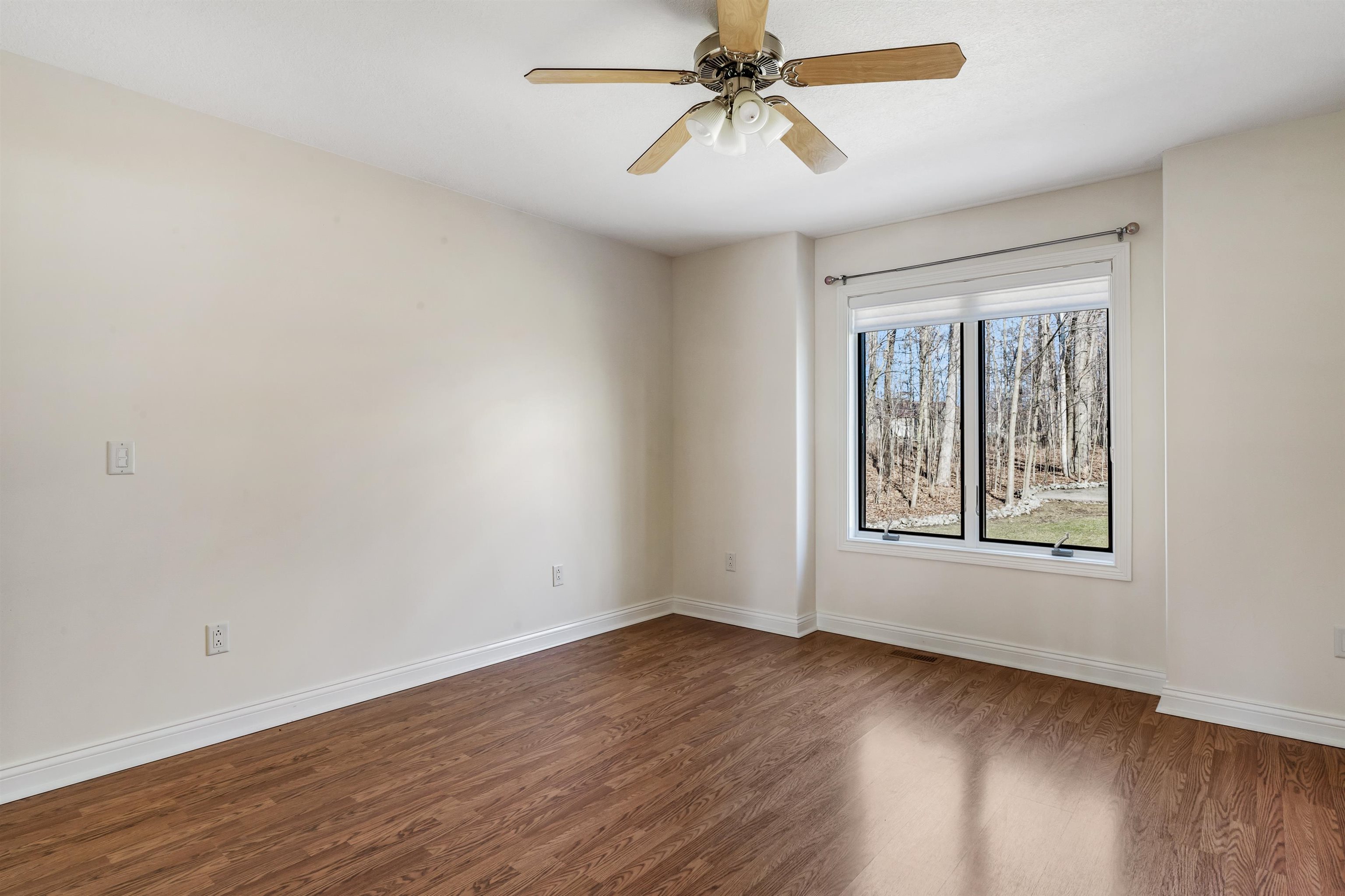 Spare room featuring dark wood-type flooring and ceiling fan