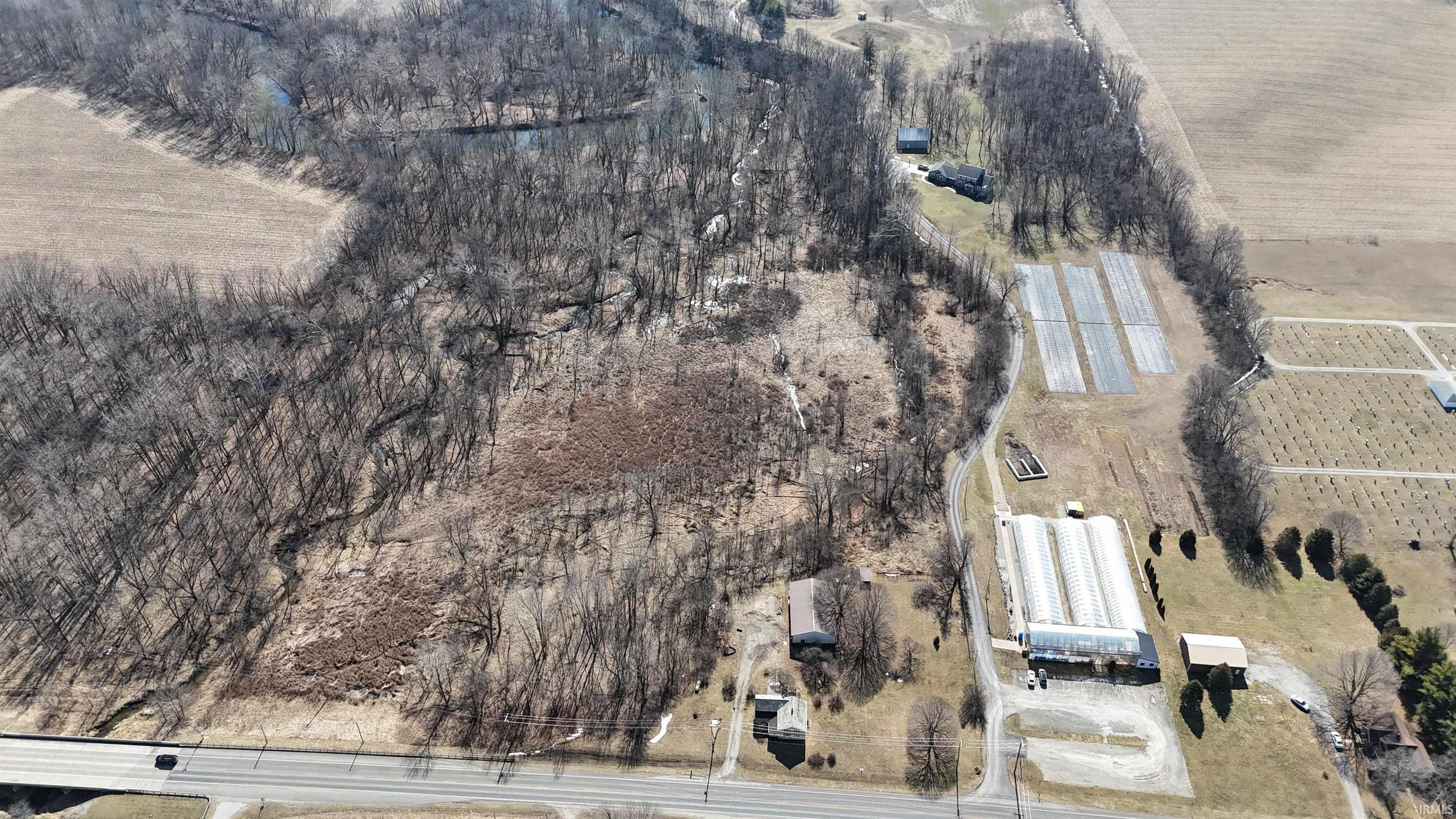 Aerial view of property and surrounding area with rural landscape and rows of crops