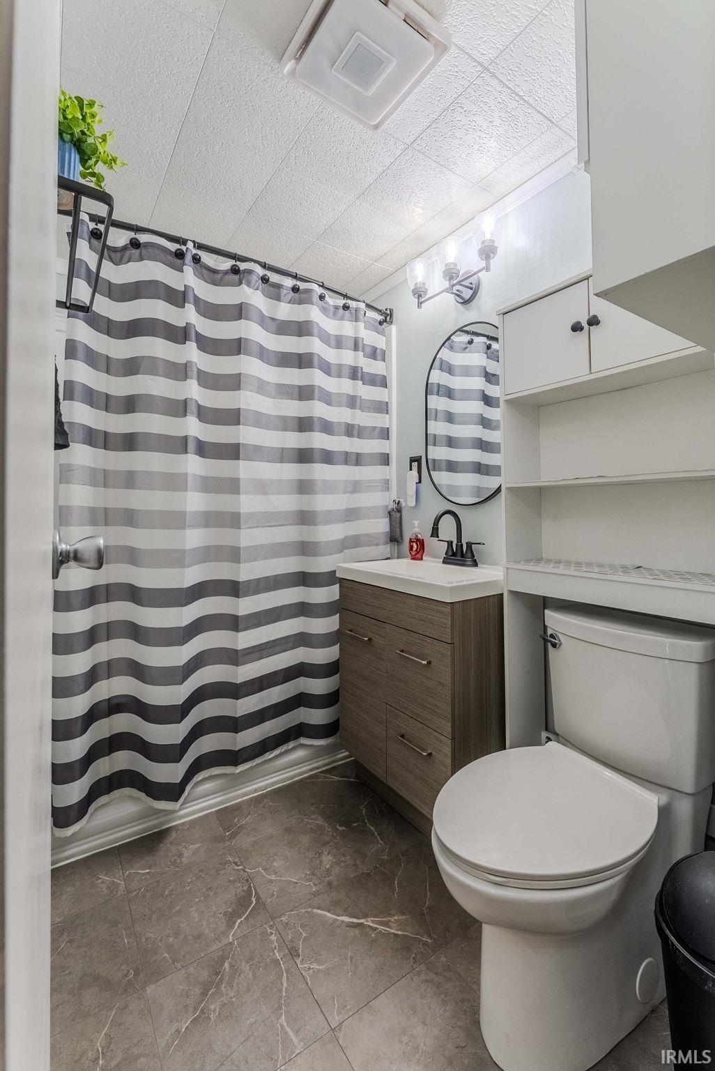 Full bathroom with vanity, a shower with shower curtain, and a paneled ceiling