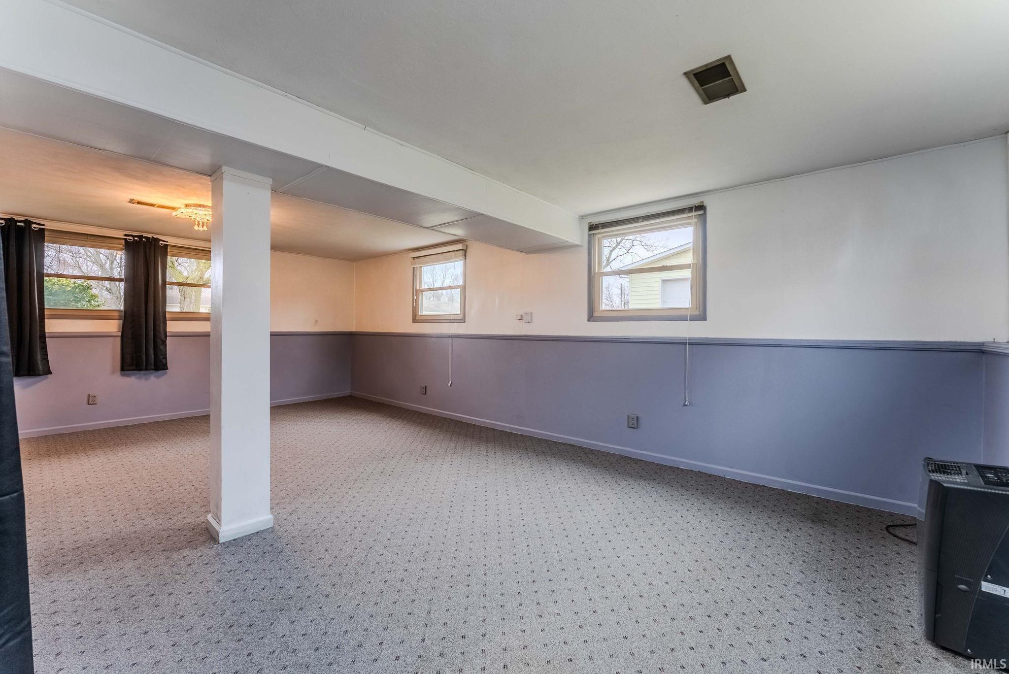 Basement with a wainscoted wall and baseboards