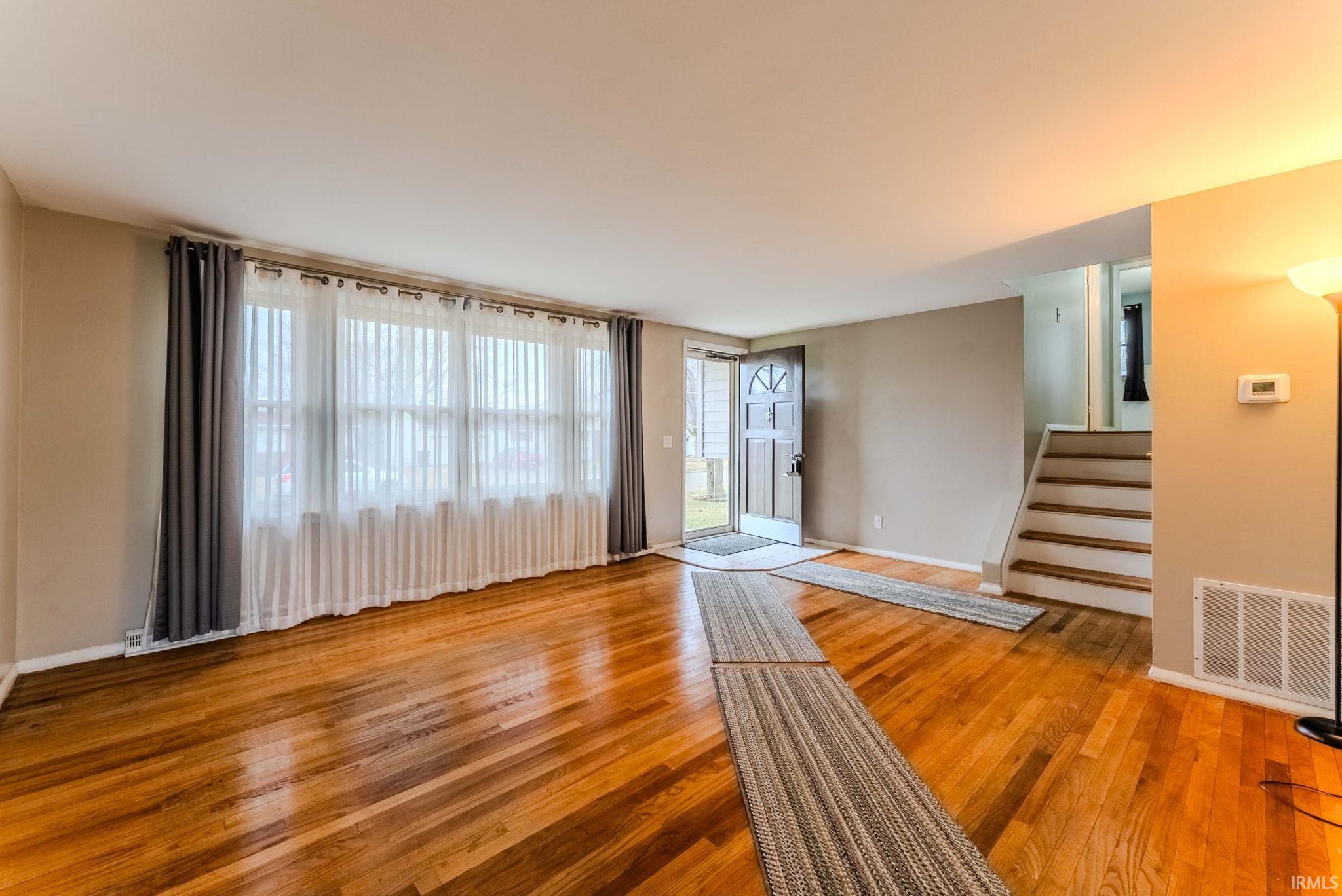 Unfurnished living room featuring light wood-style floors and plenty of natural light
