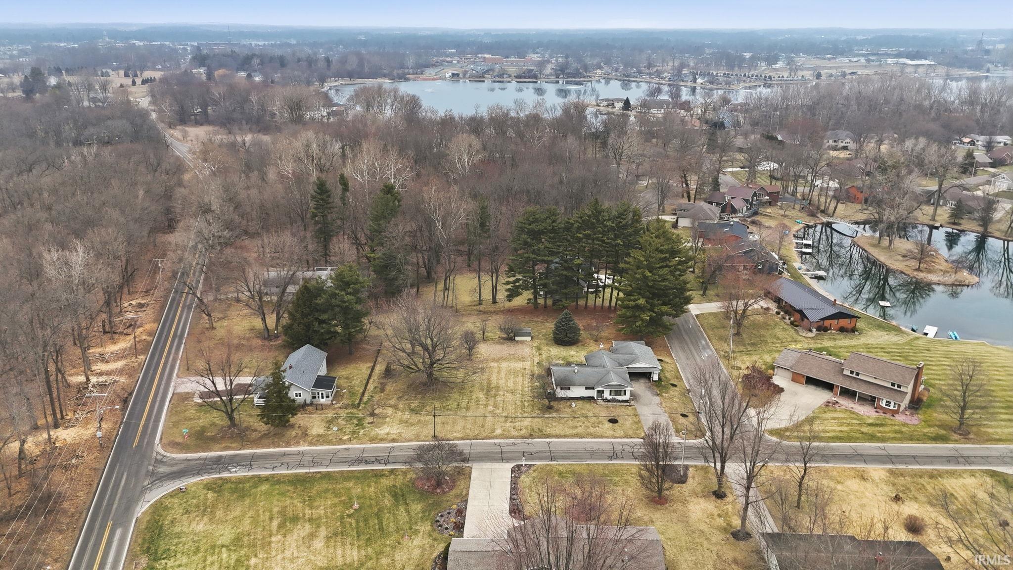 Aerial view of property and surrounding area featuring a large body of water and nearby suburban area