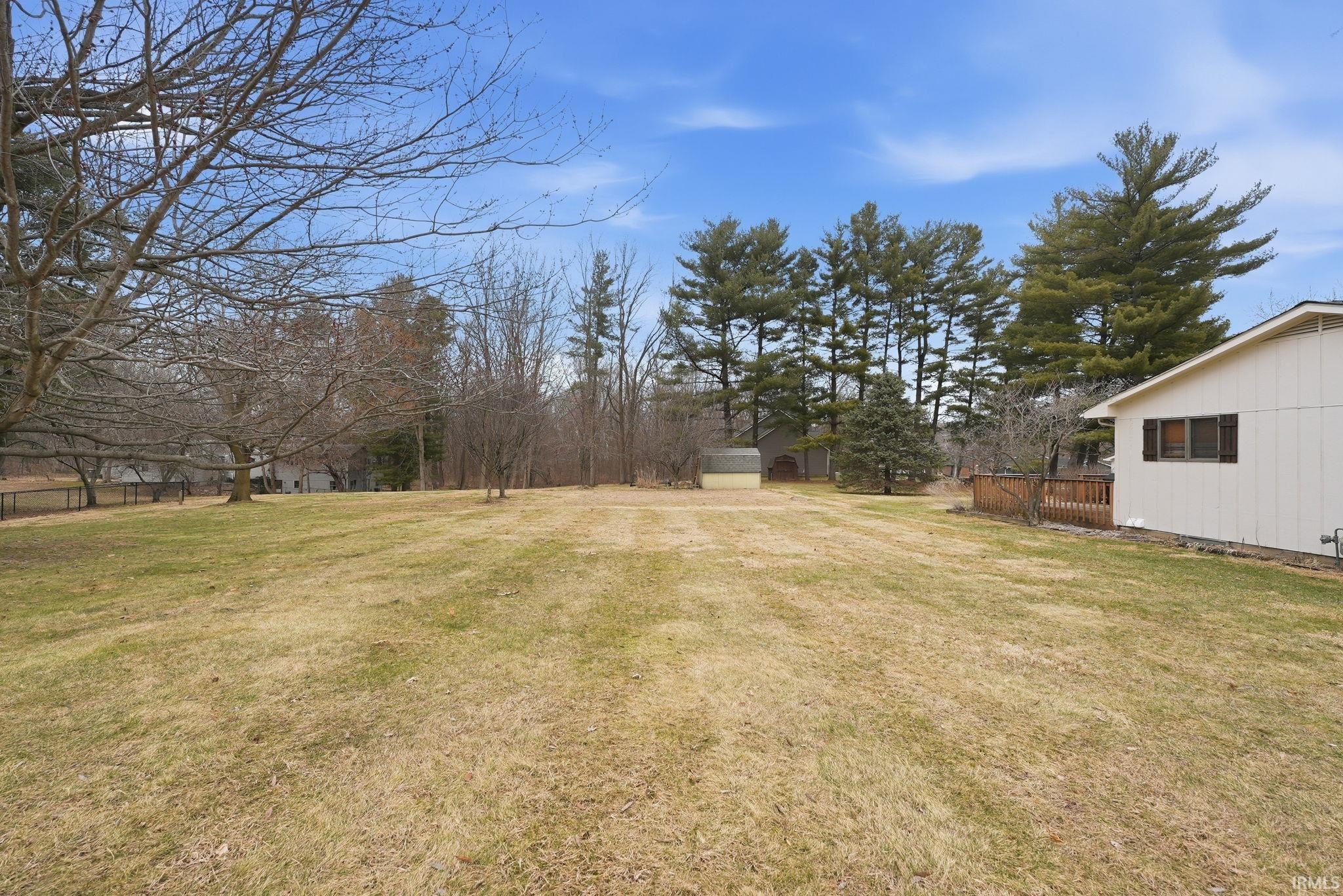 View of green lawn featuring a shed