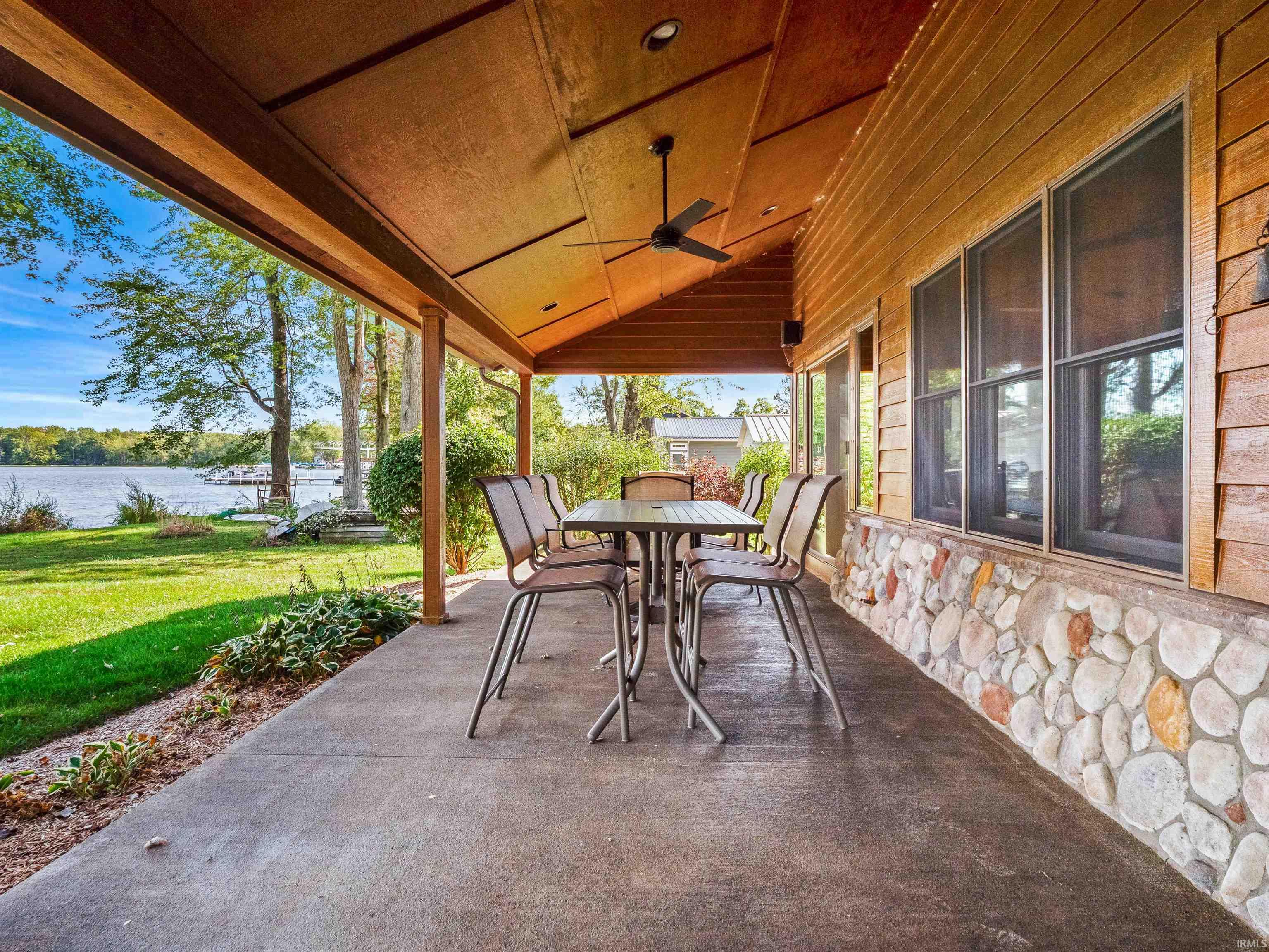 View of patio / terrace with a ceiling fan, outdoor dining area, and a water view