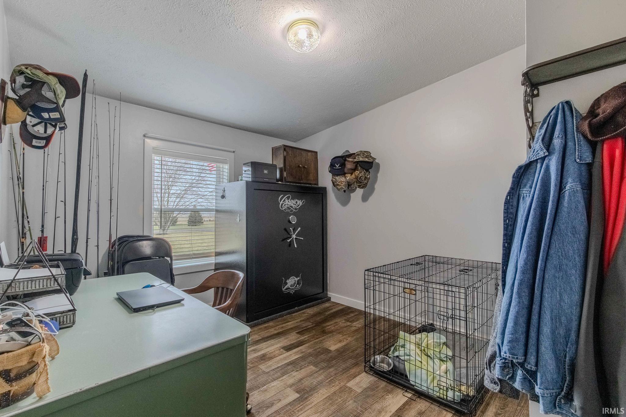 Home office featuring dark wood-style floors and a textured ceiling