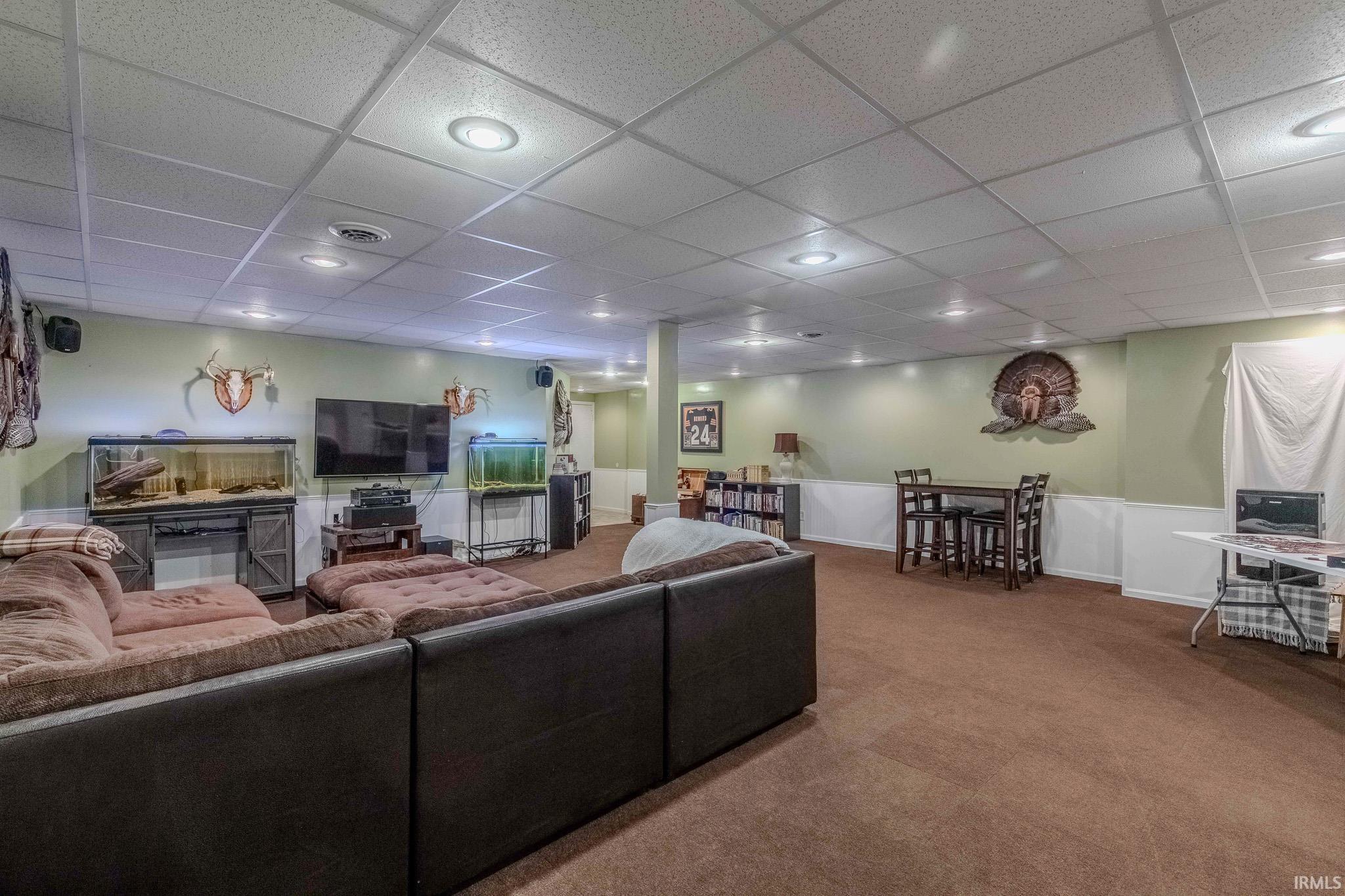 Carpeted living area with a paneled ceiling and recessed lighting