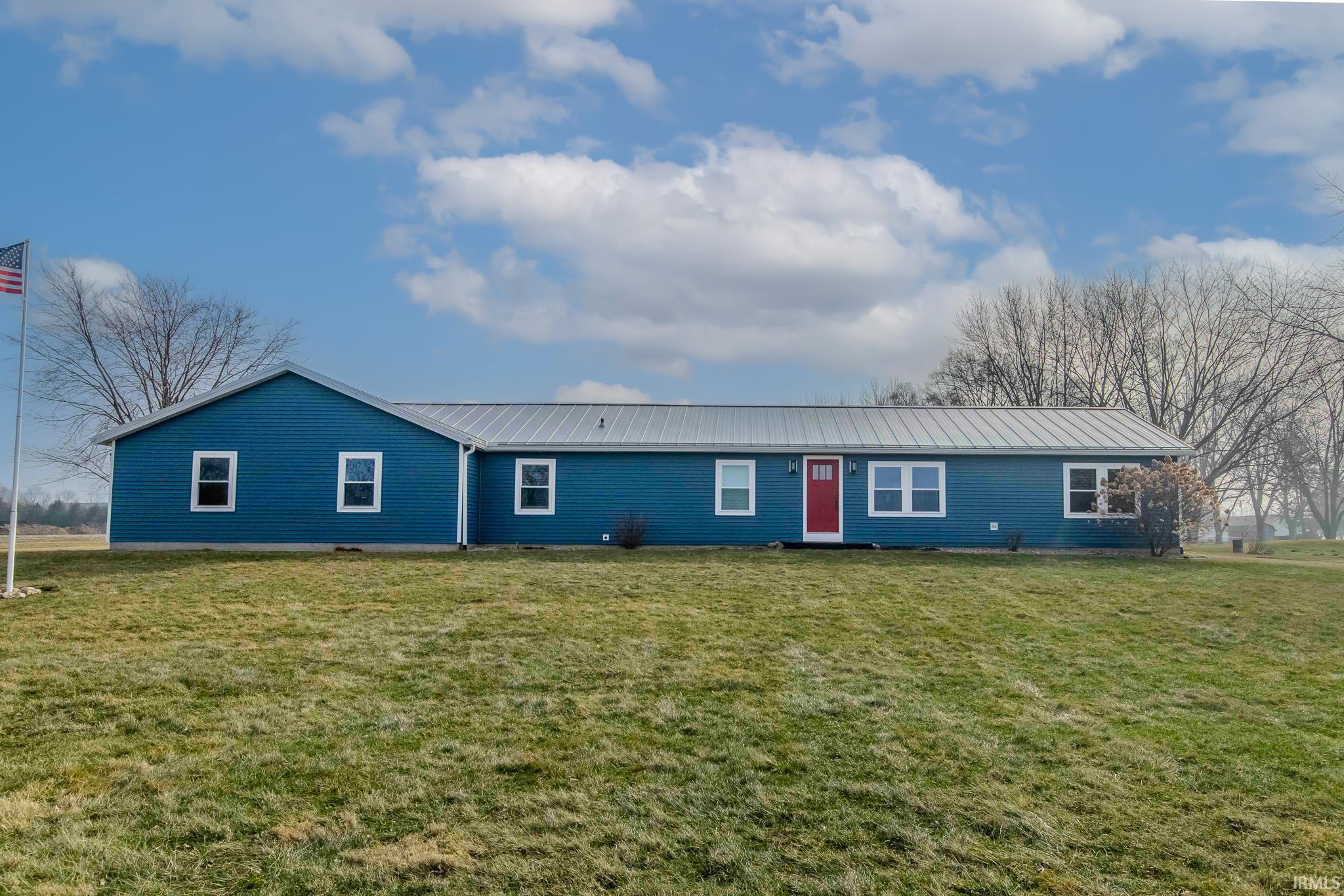 View of front facade featuring a metal roof and a front lawn