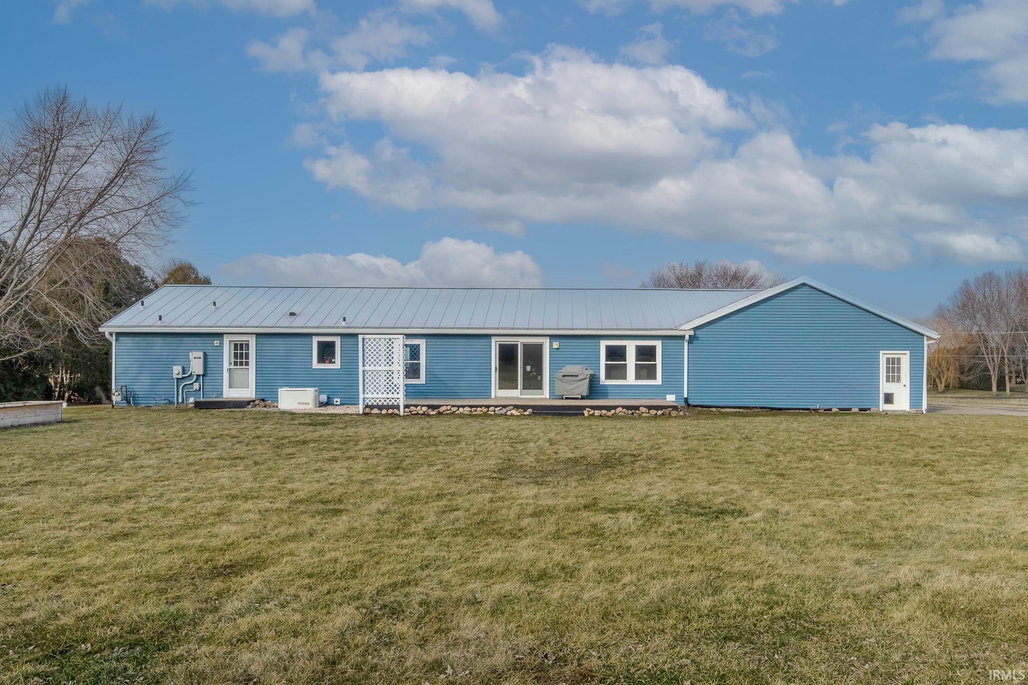 Single story home with a front yard and a metal roof
