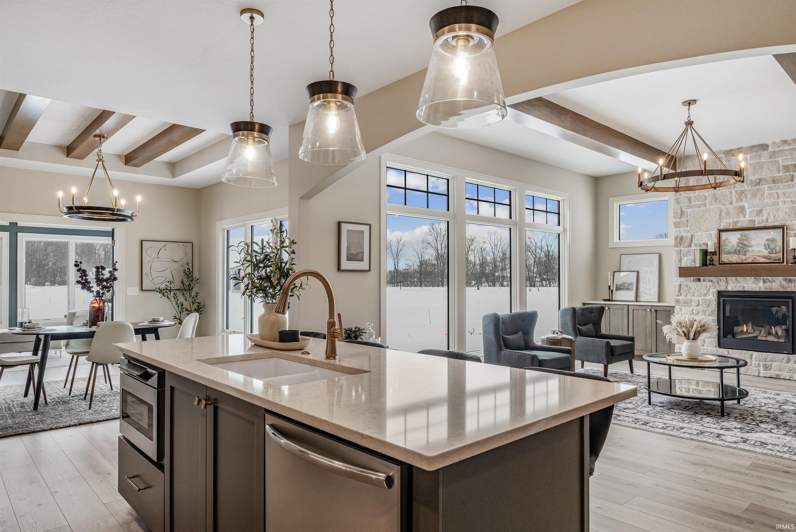 Kitchen featuring a chandelier, decorative light fixtures, beam ceiling, light stone counters, and stainless steel dishwasher