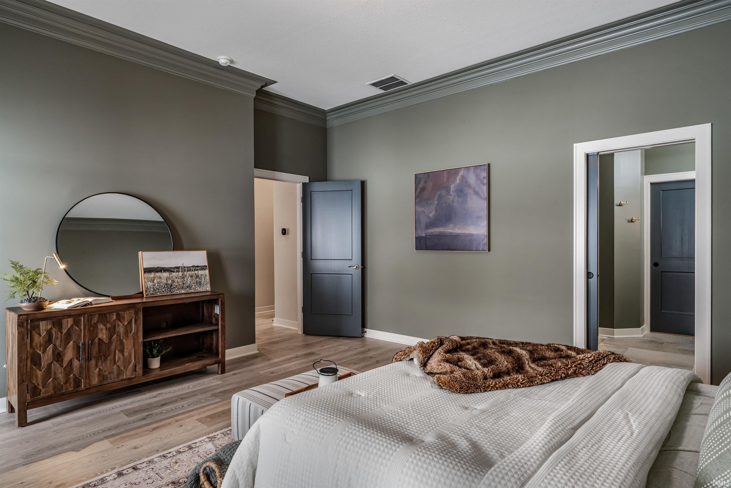 Bedroom featuring crown molding and wood finished floors