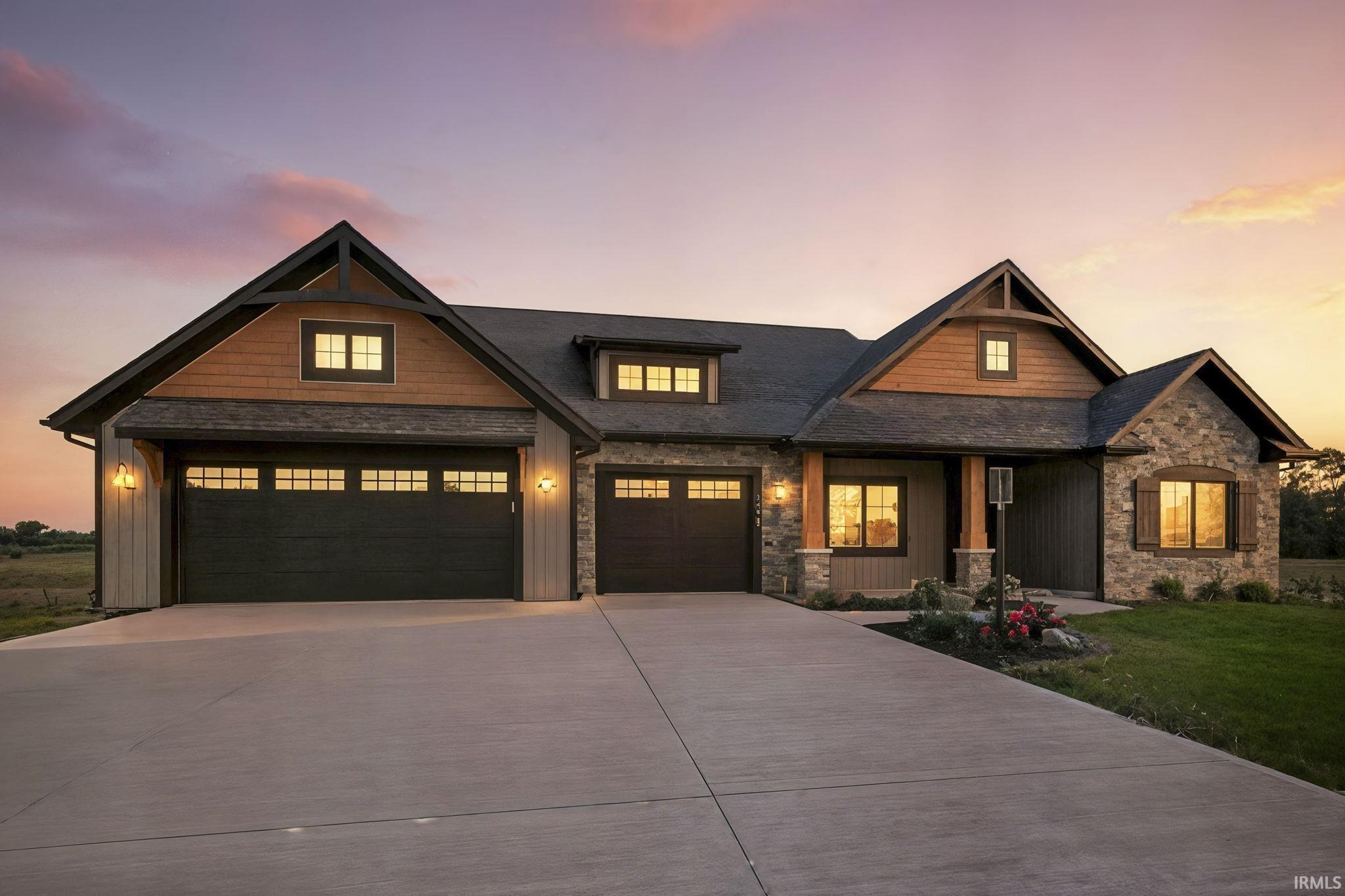 Craftsman inspired home featuring stone siding, driveway, and board and batten siding