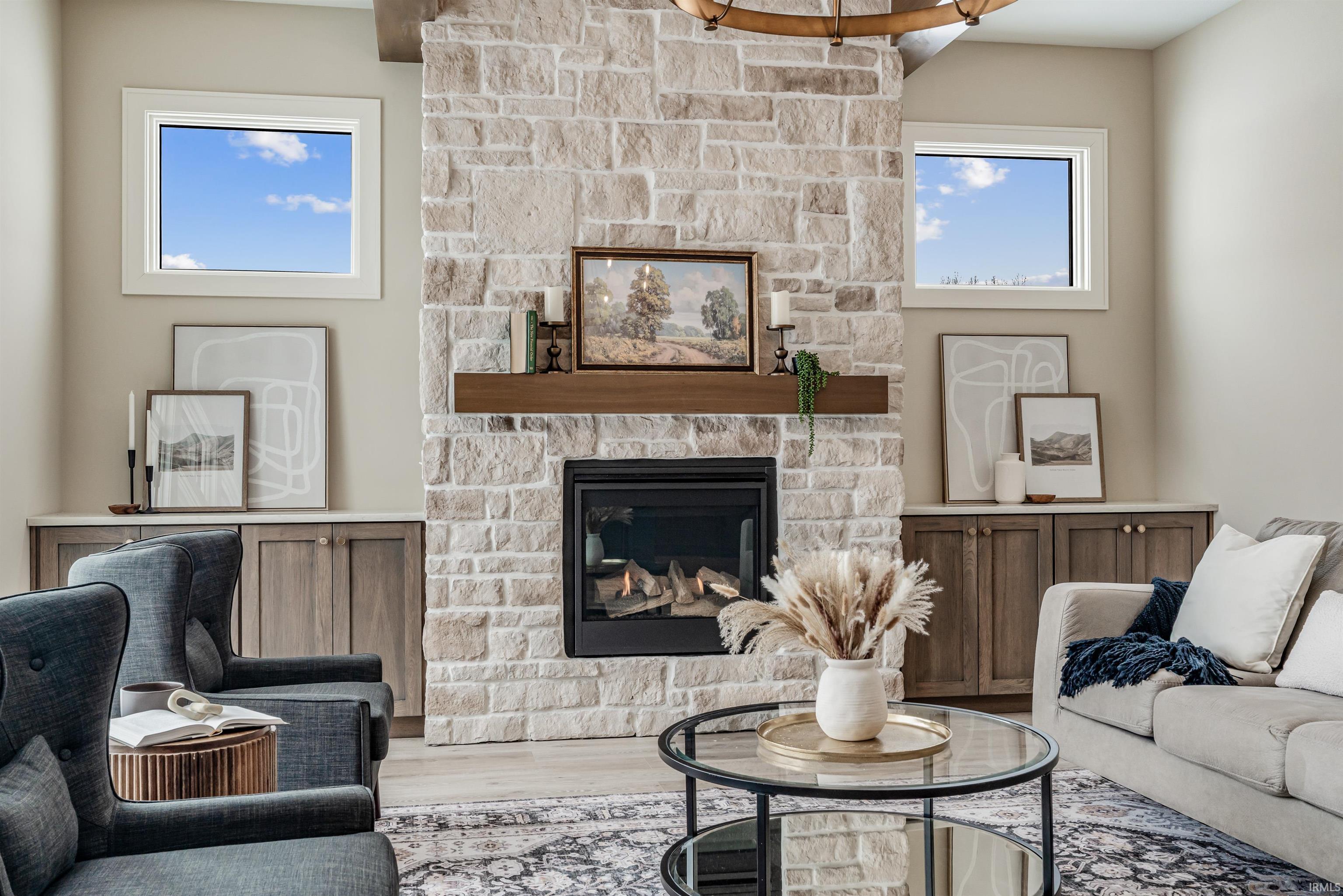 Living area featuring a stone fireplace and wood finished floors