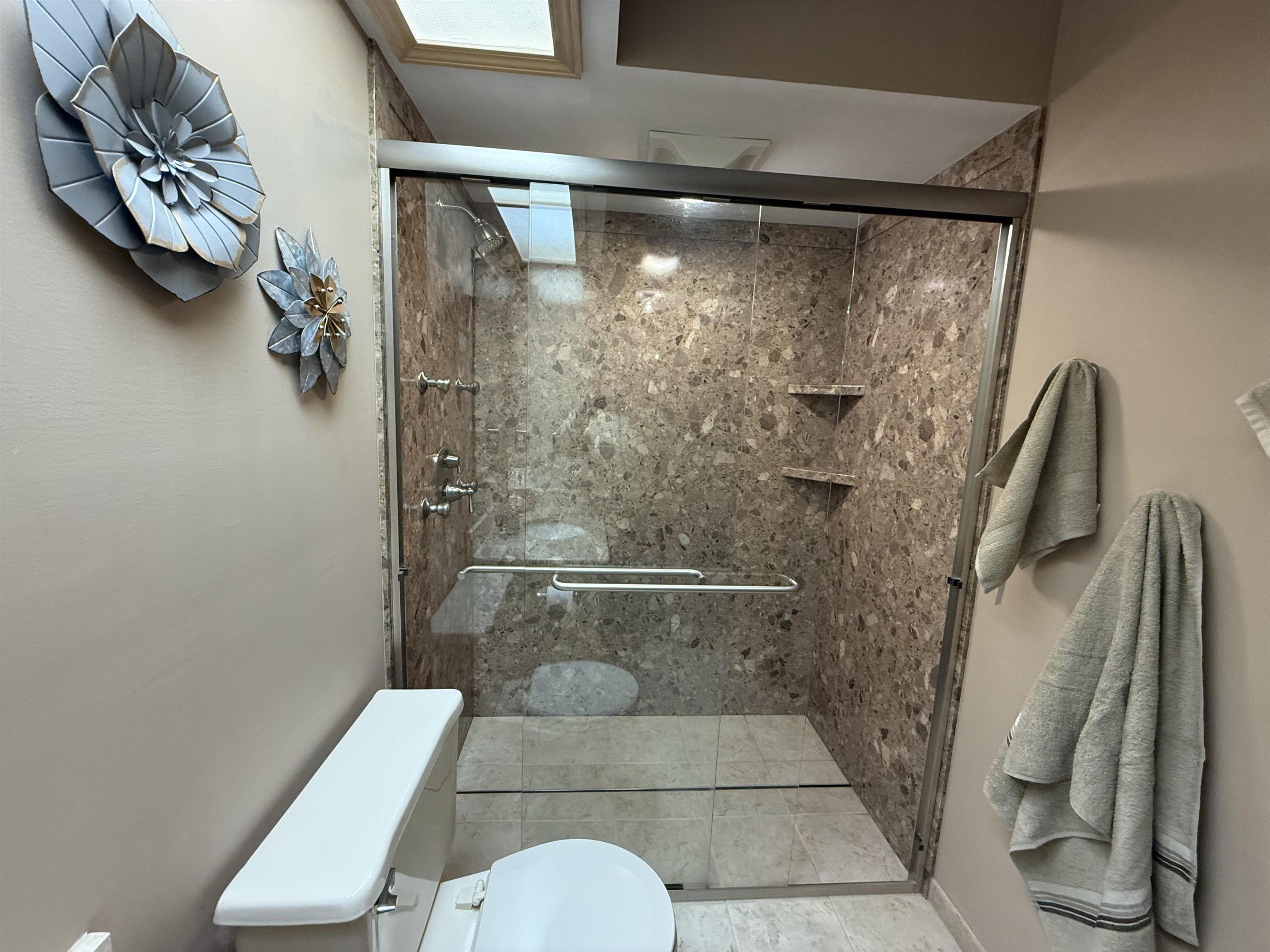 Bathroom featuring toilet and a shower stall