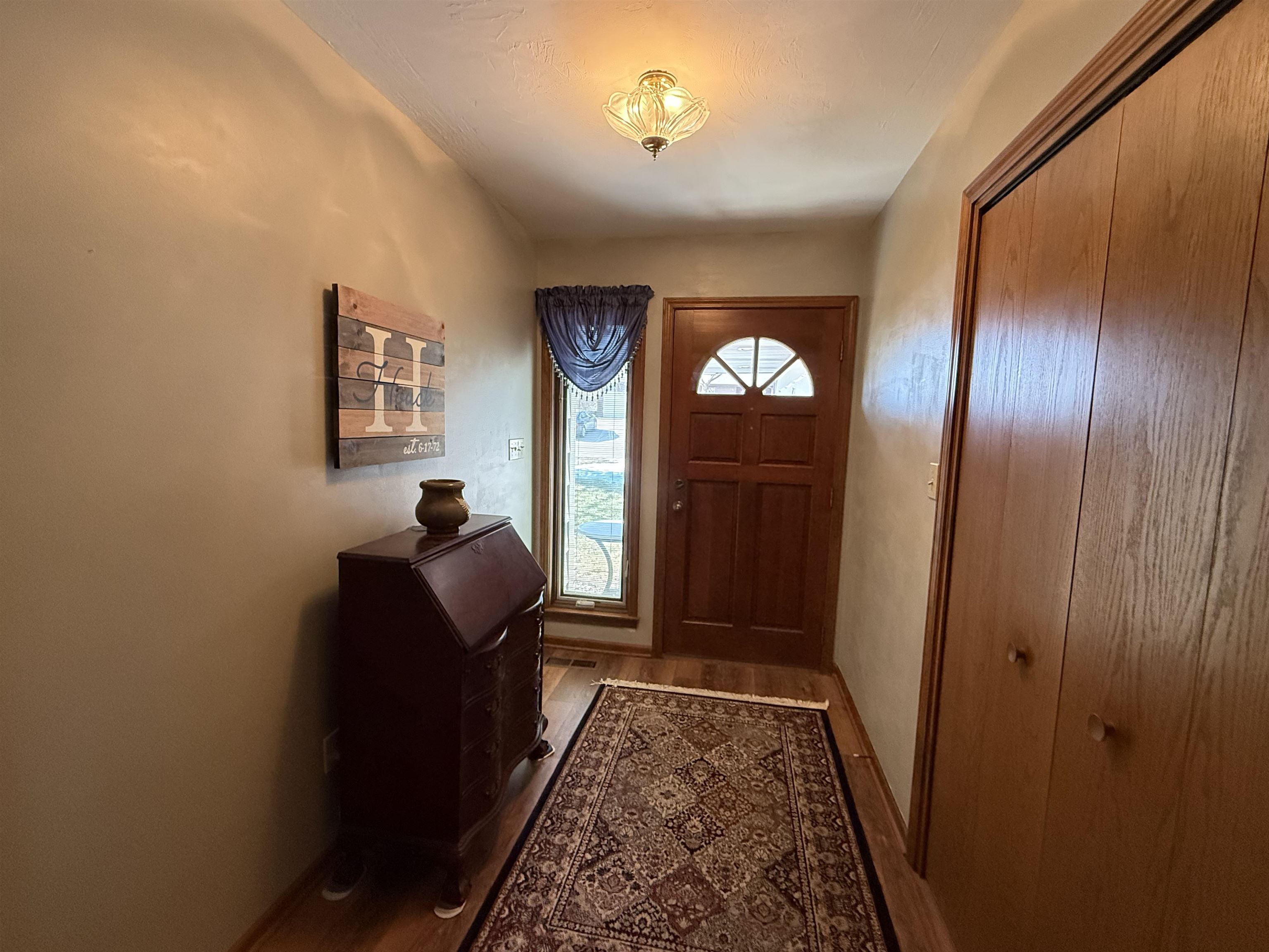 Entrance foyer with dark wood-style floors and baseboards