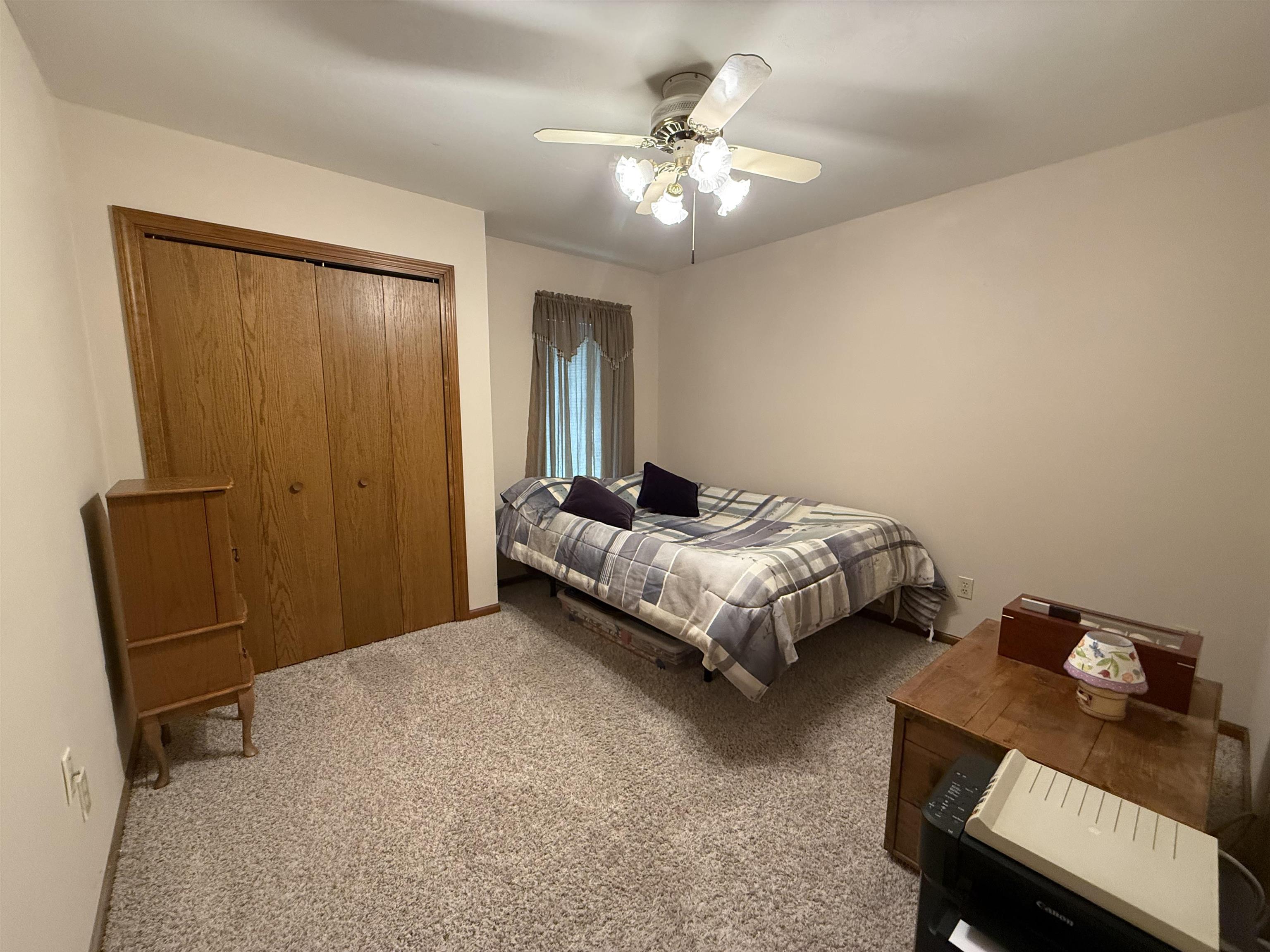 Carpeted bedroom featuring a closet and a ceiling fan