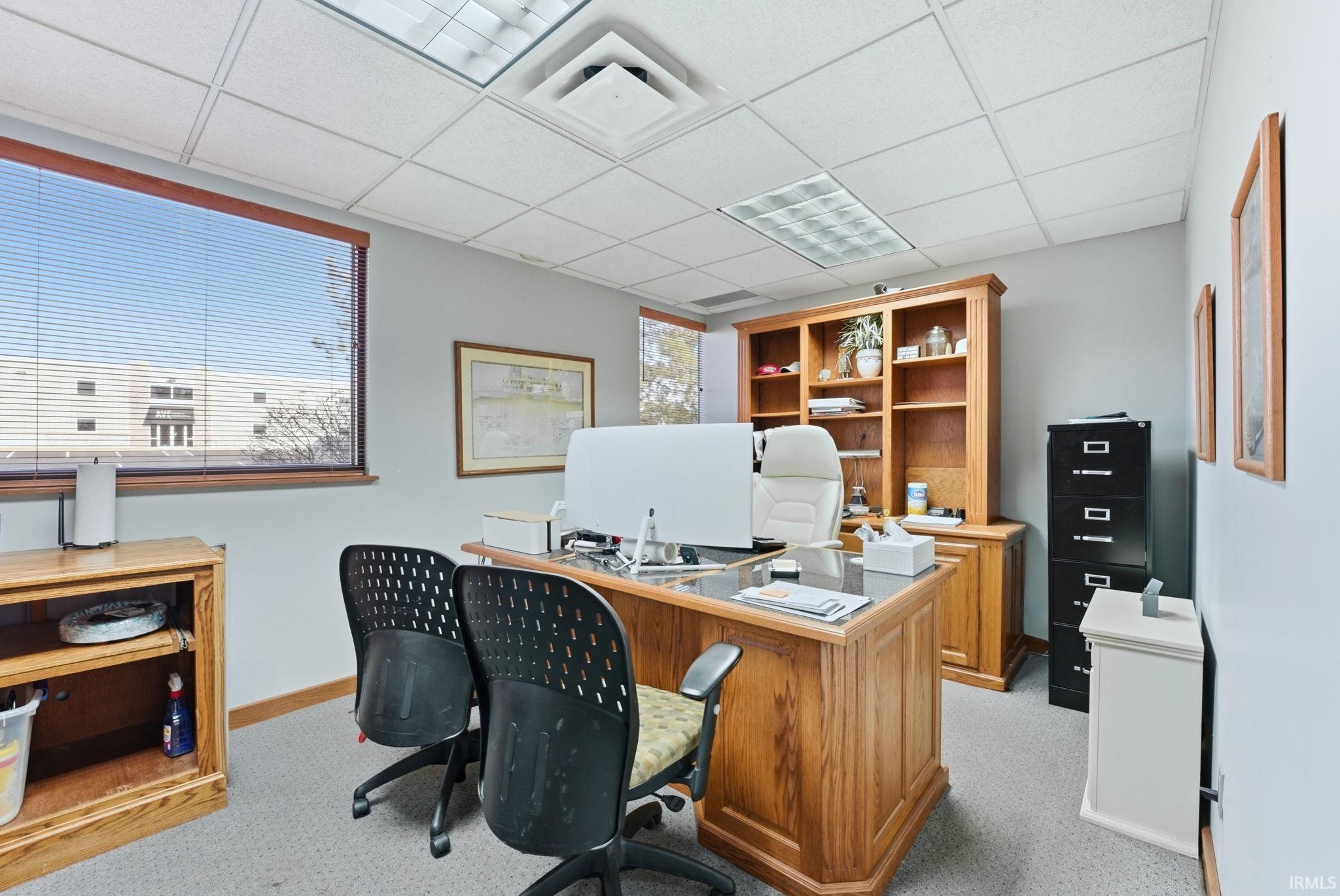 Office space with a drop ceiling and healthy amount of natural light