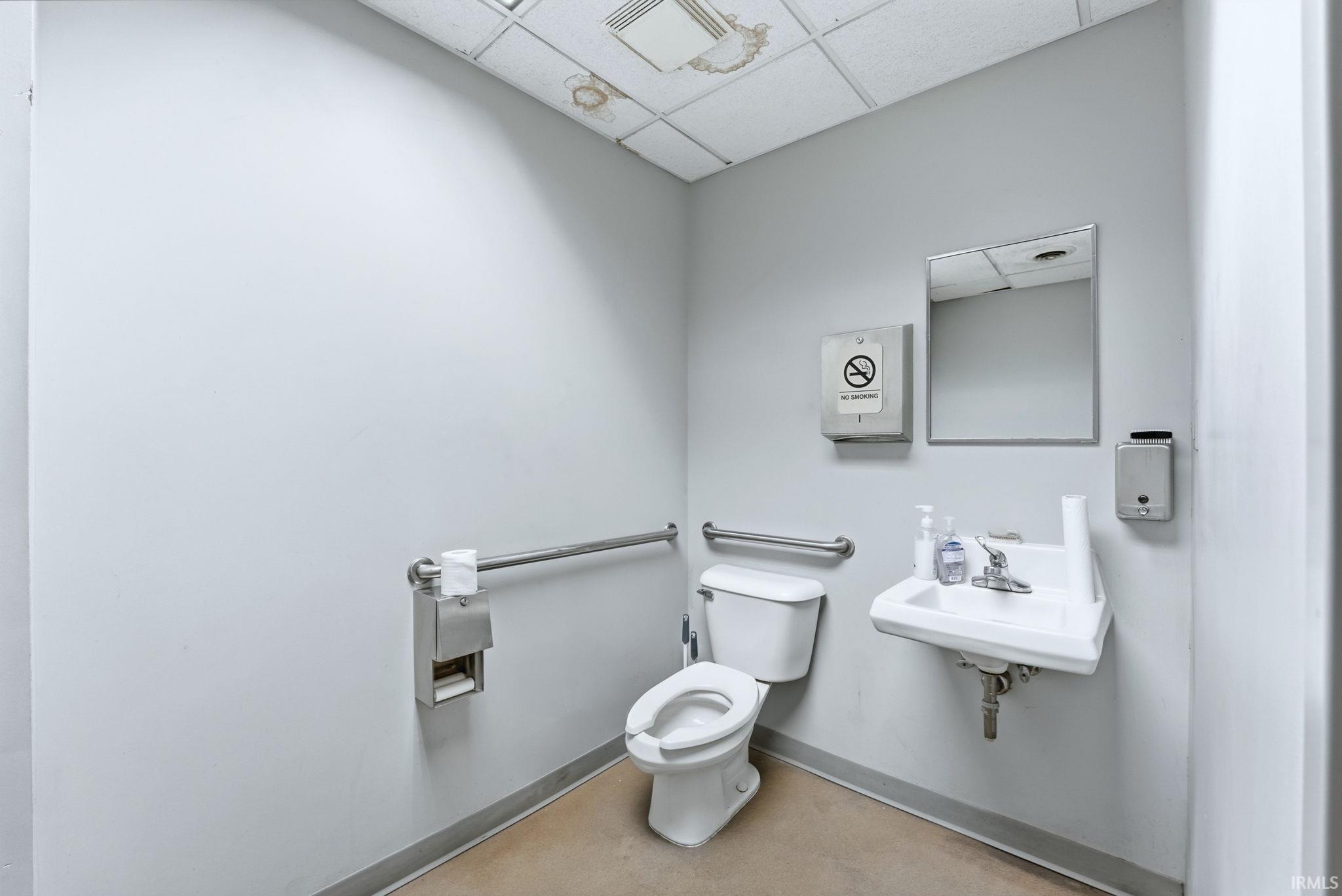 Half bathroom featuring toilet and a paneled ceiling
