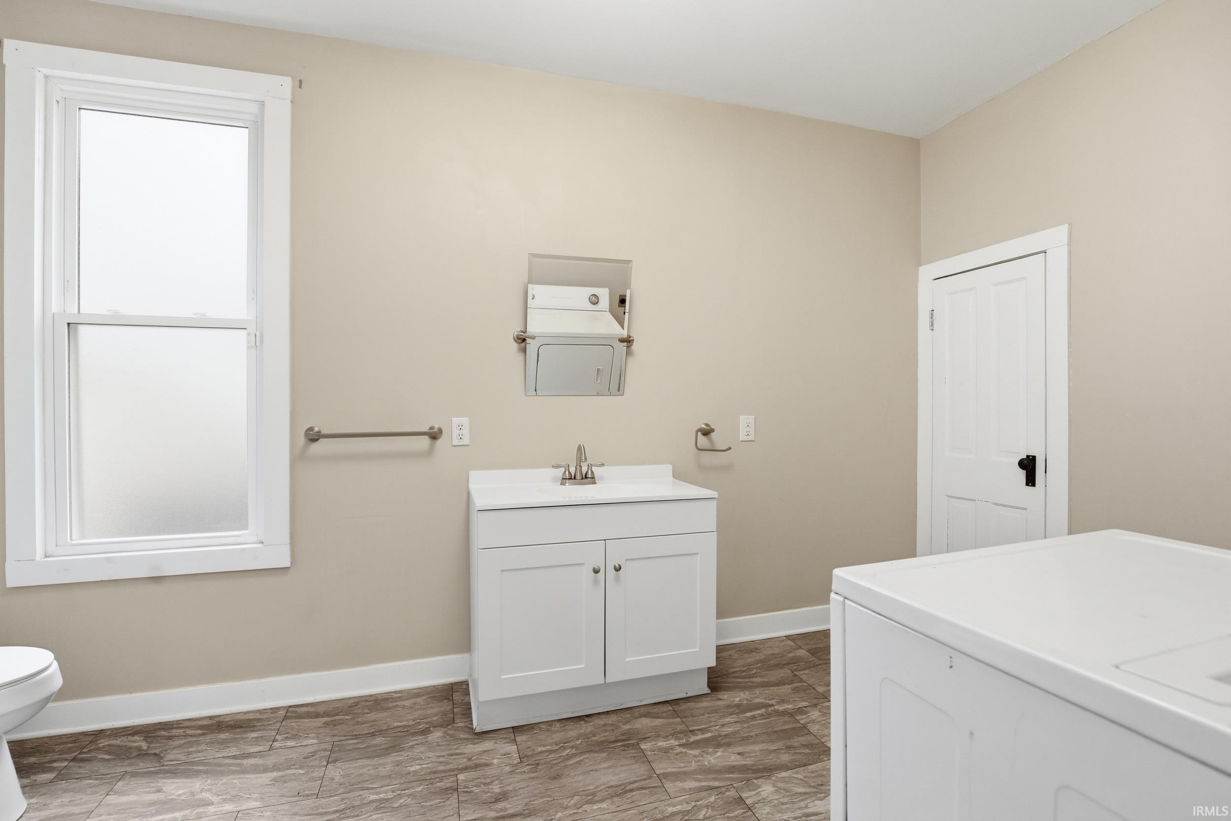 Full bathroom with two vanities and washer / clothes dryer