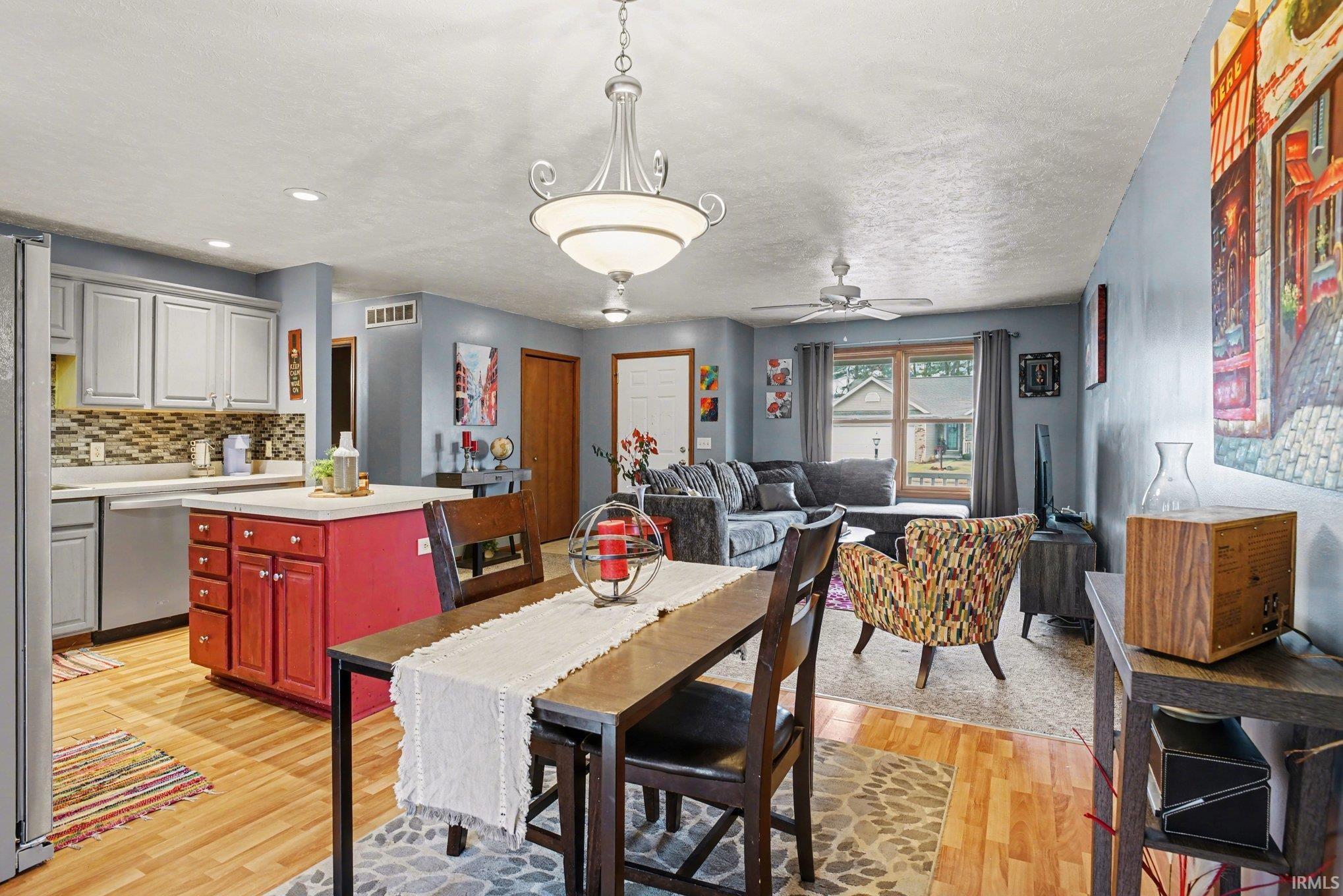 Dining space featuring ceiling fan, light wood-style floors, and a textured ceiling
