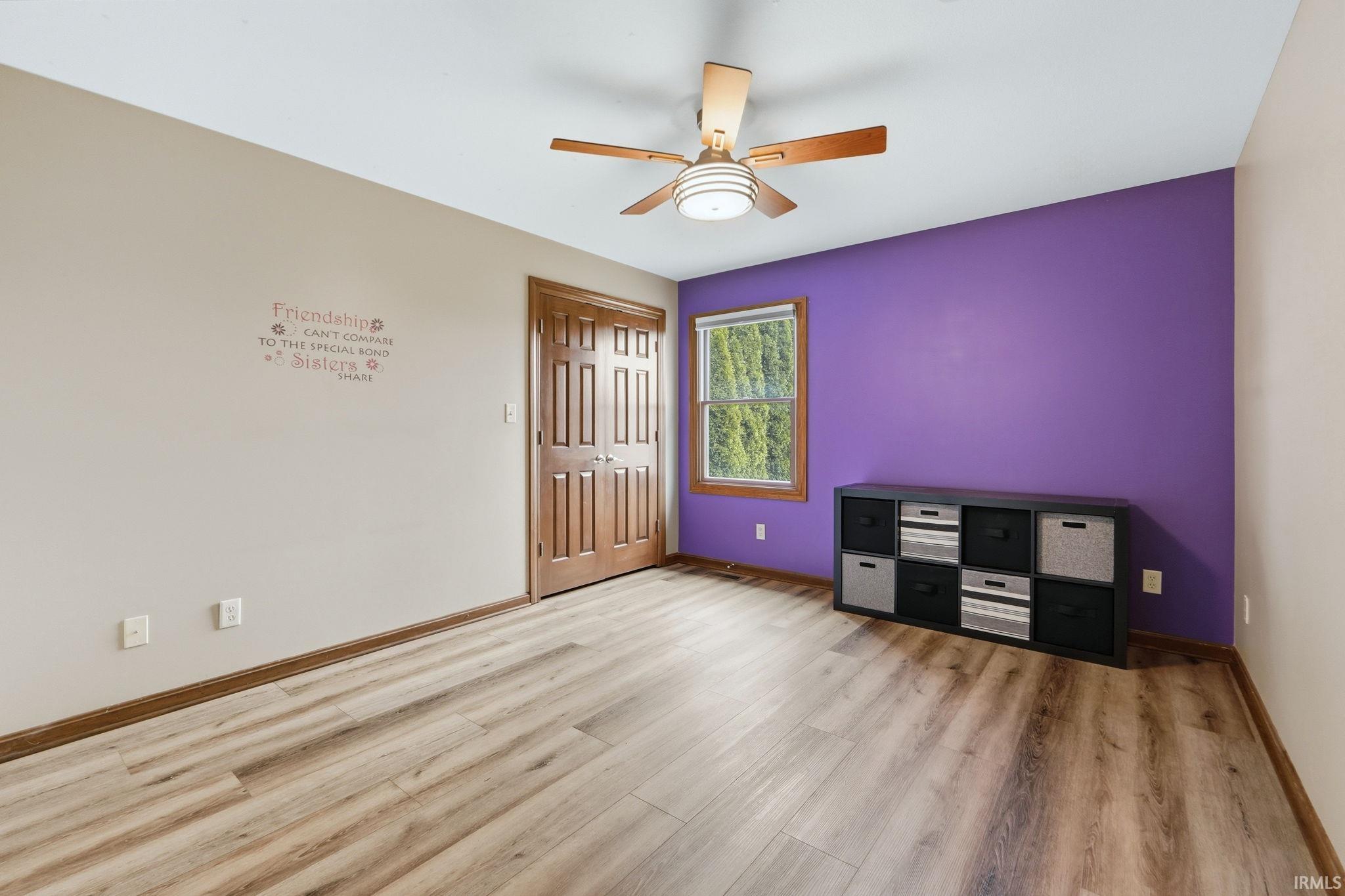 Unfurnished bedroom featuring ceiling fan, light wood-type flooring, and a closet