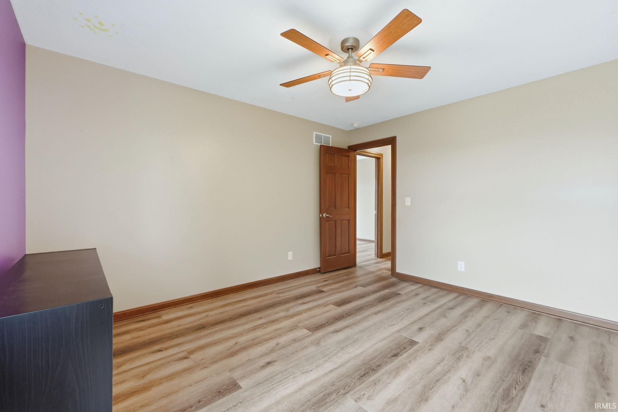 Spare room featuring light wood-style flooring and a ceiling fan