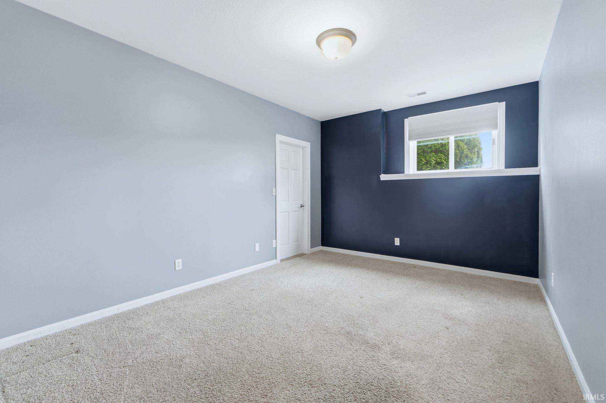 Spare room featuring baseboards and light colored carpet