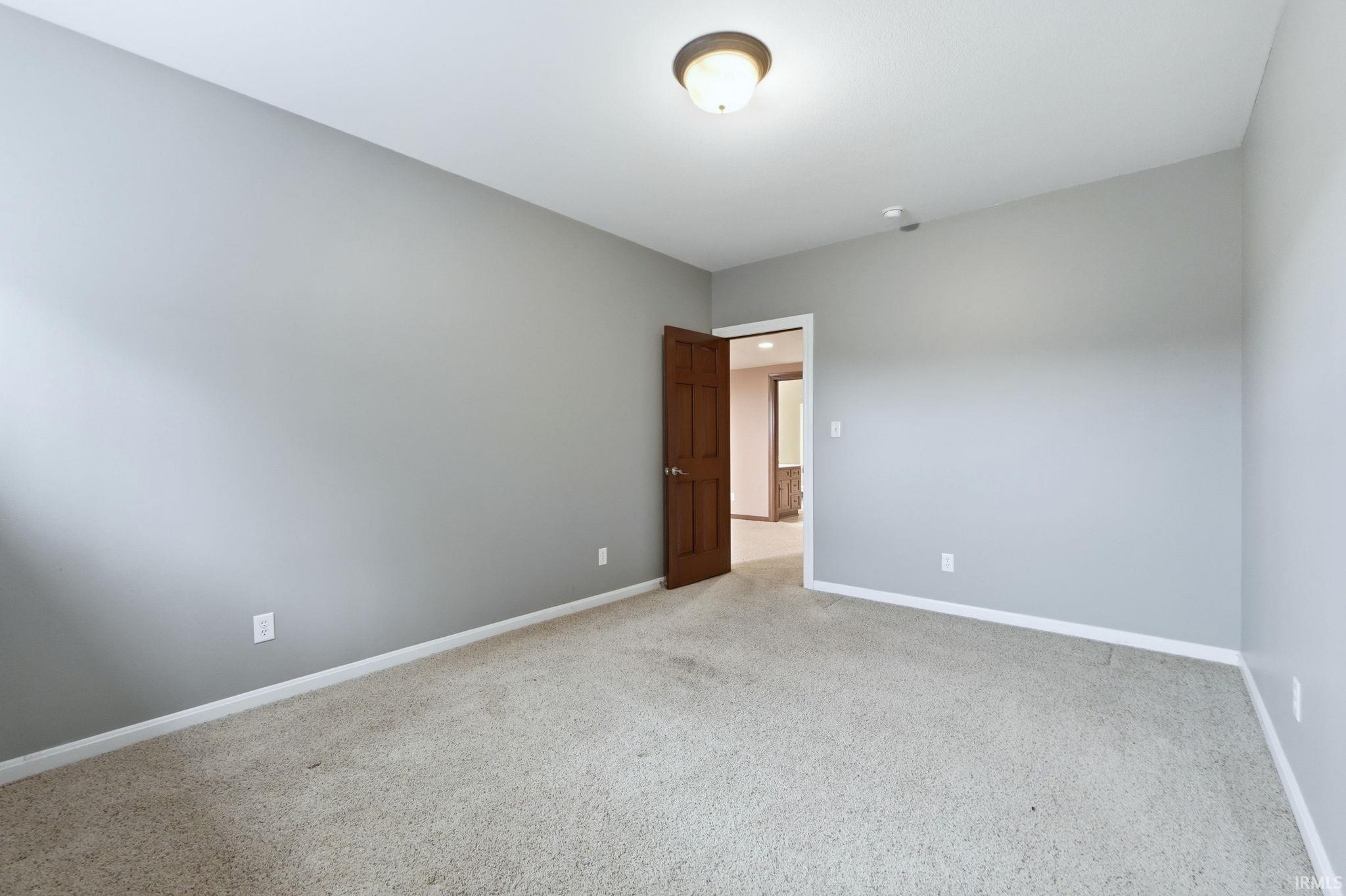 Unfurnished room featuring baseboards and light colored carpet