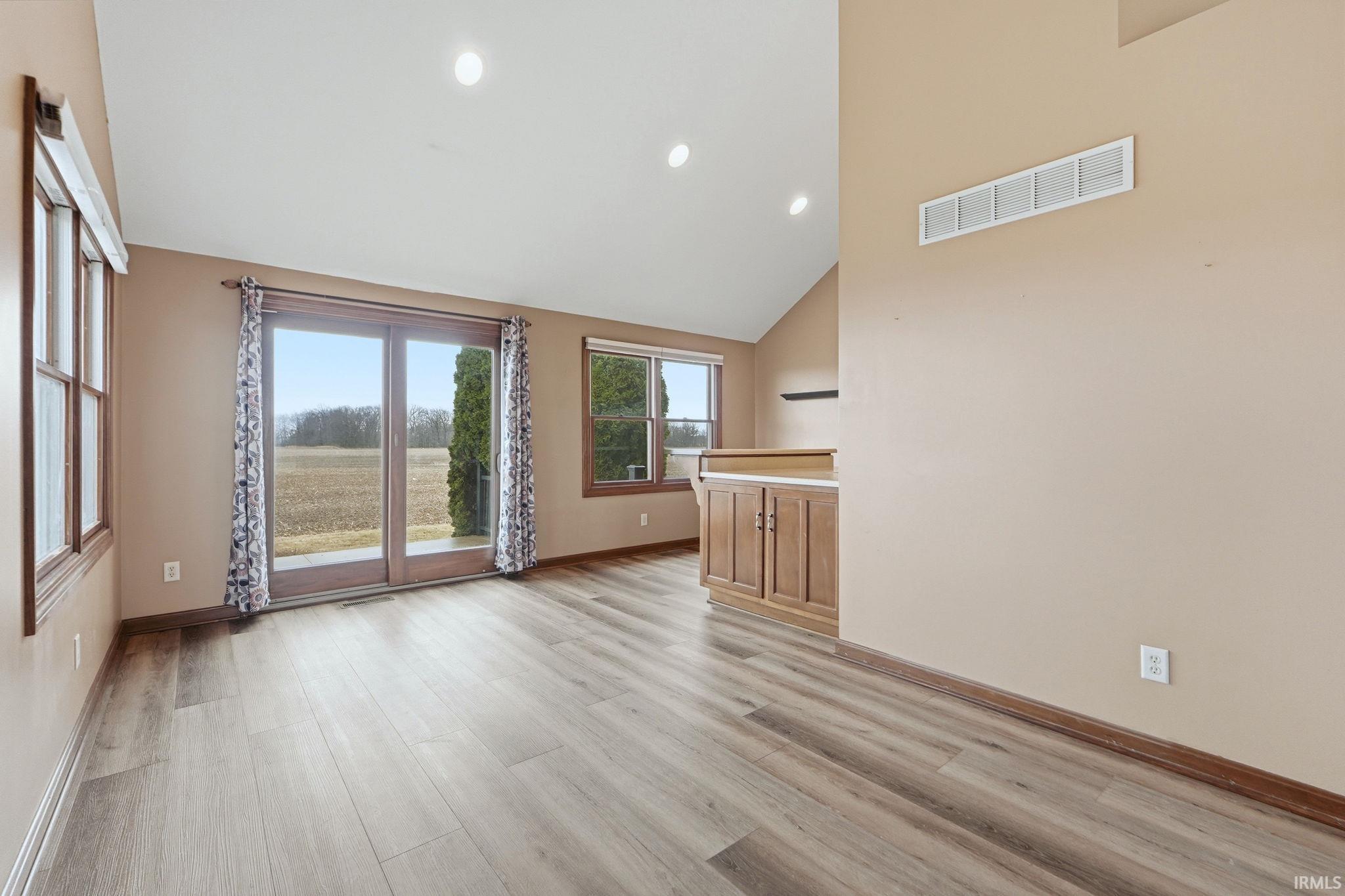 Unfurnished living room with light wood-style flooring, recessed lighting, and lofted ceiling