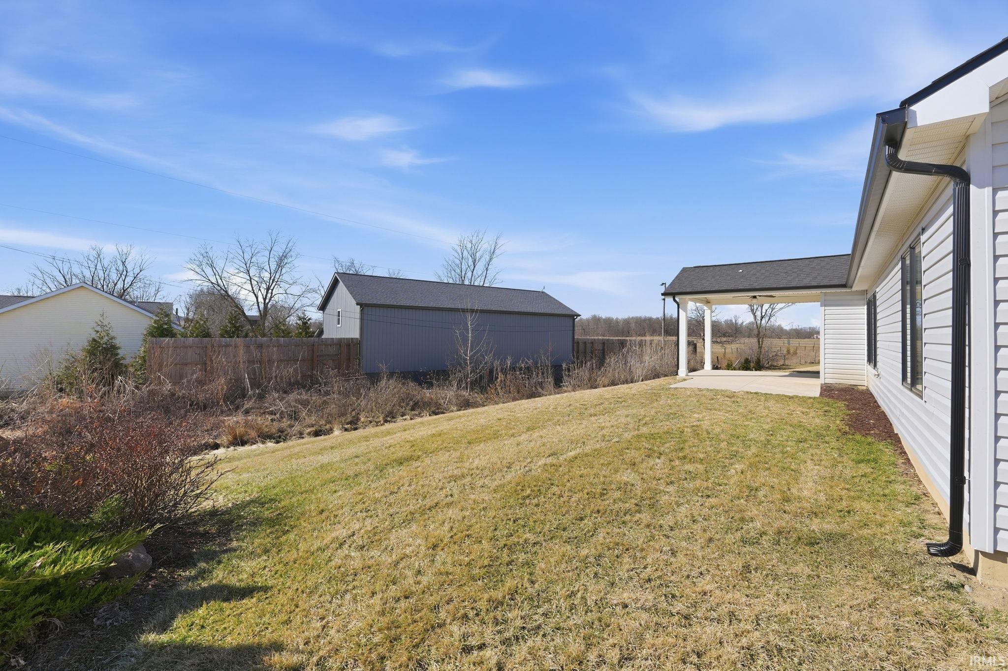 Fenced yard with an outdoor structure and a patio