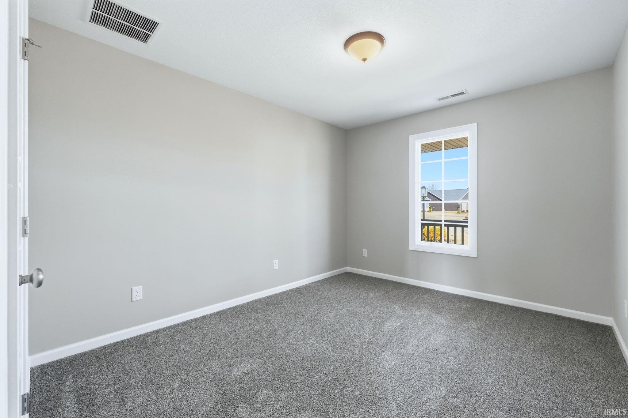Unfurnished room with baseboards and dark carpet