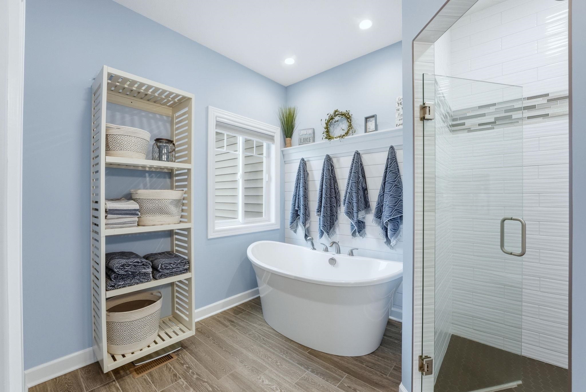 Bathroom featuring a stall shower, wood finish floors, and a freestanding bath