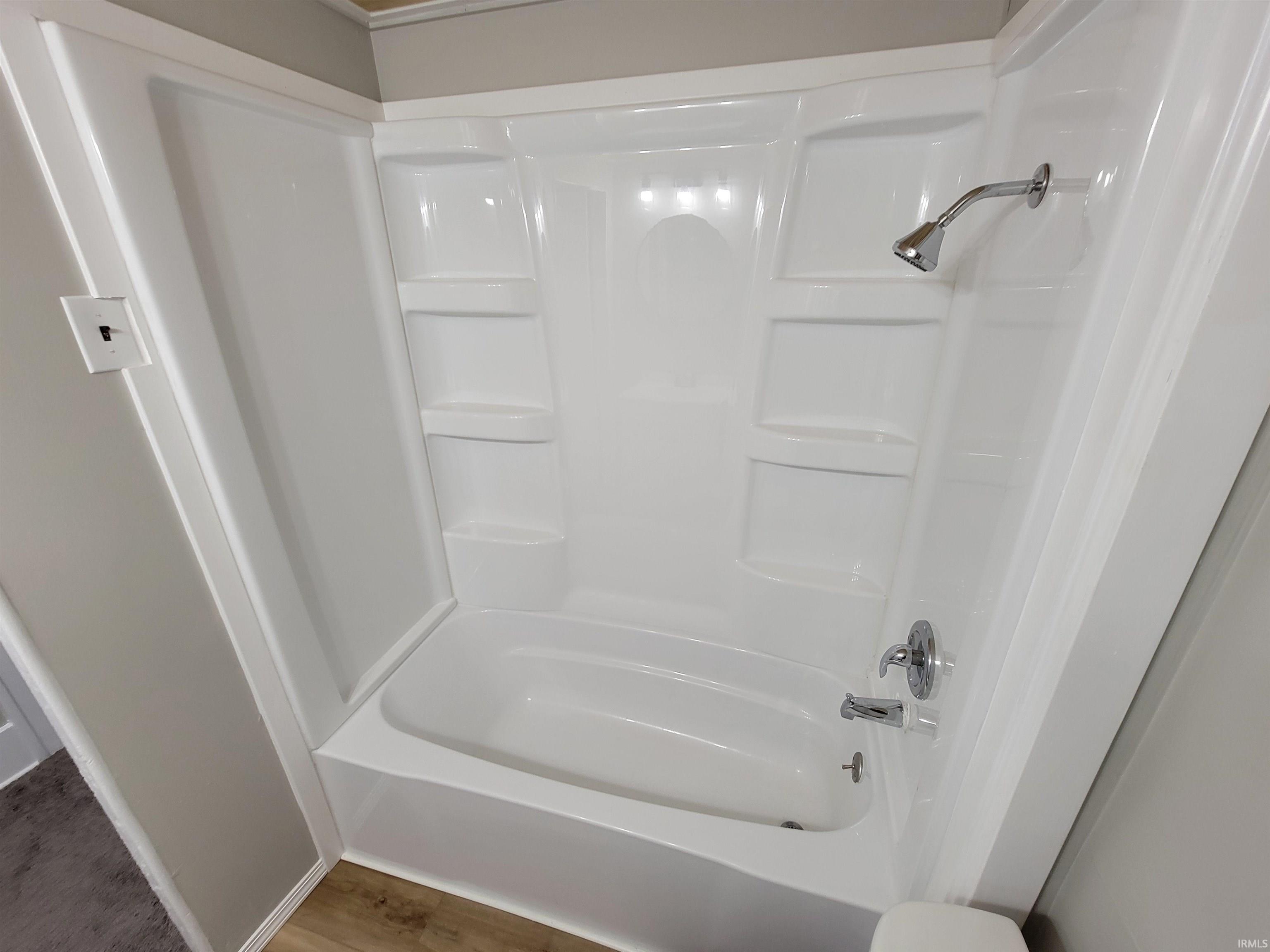 Bathroom with light wood-style floors and shower / bathtub combination