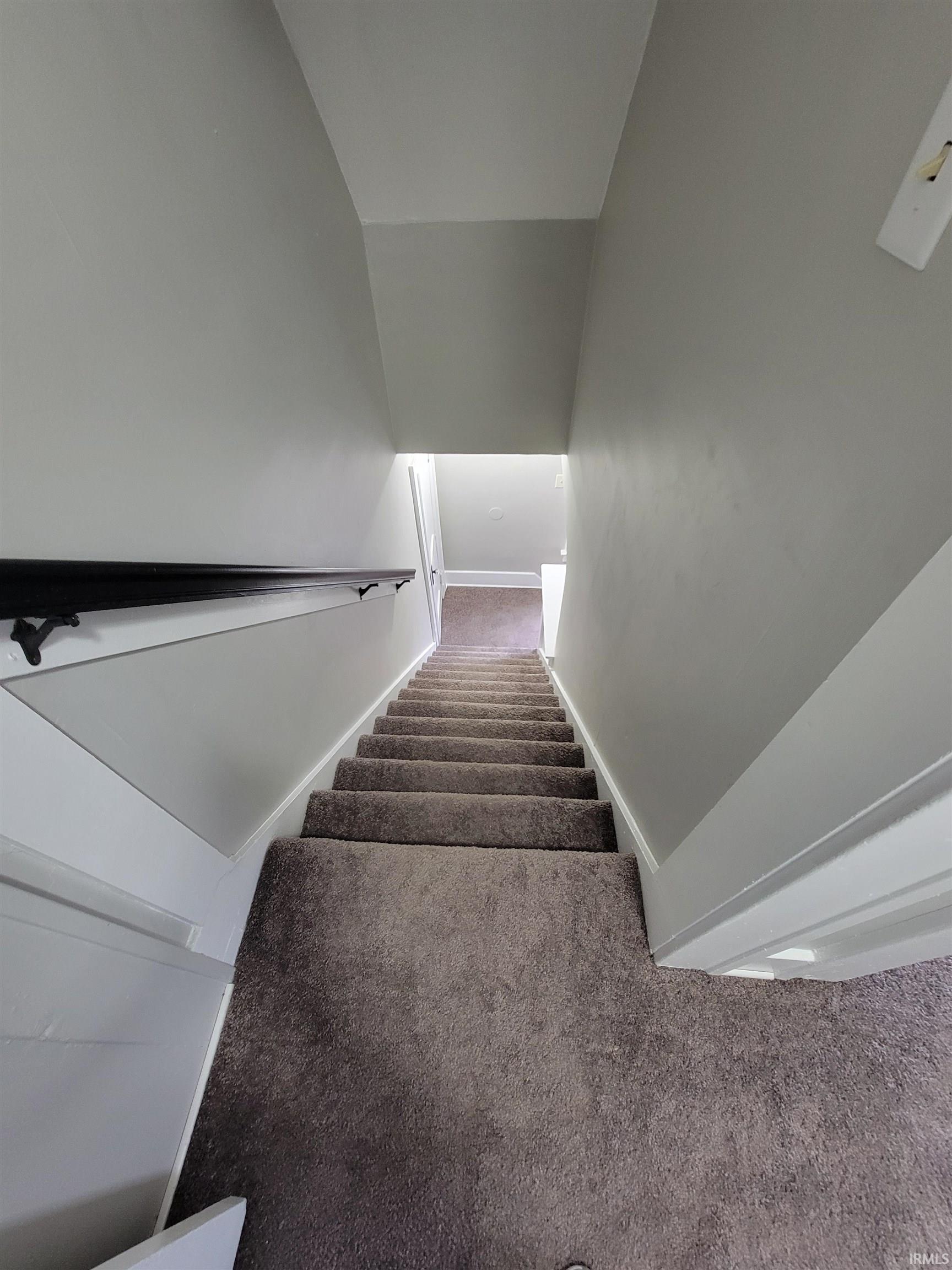 Stairway with carpet floors and baseboards