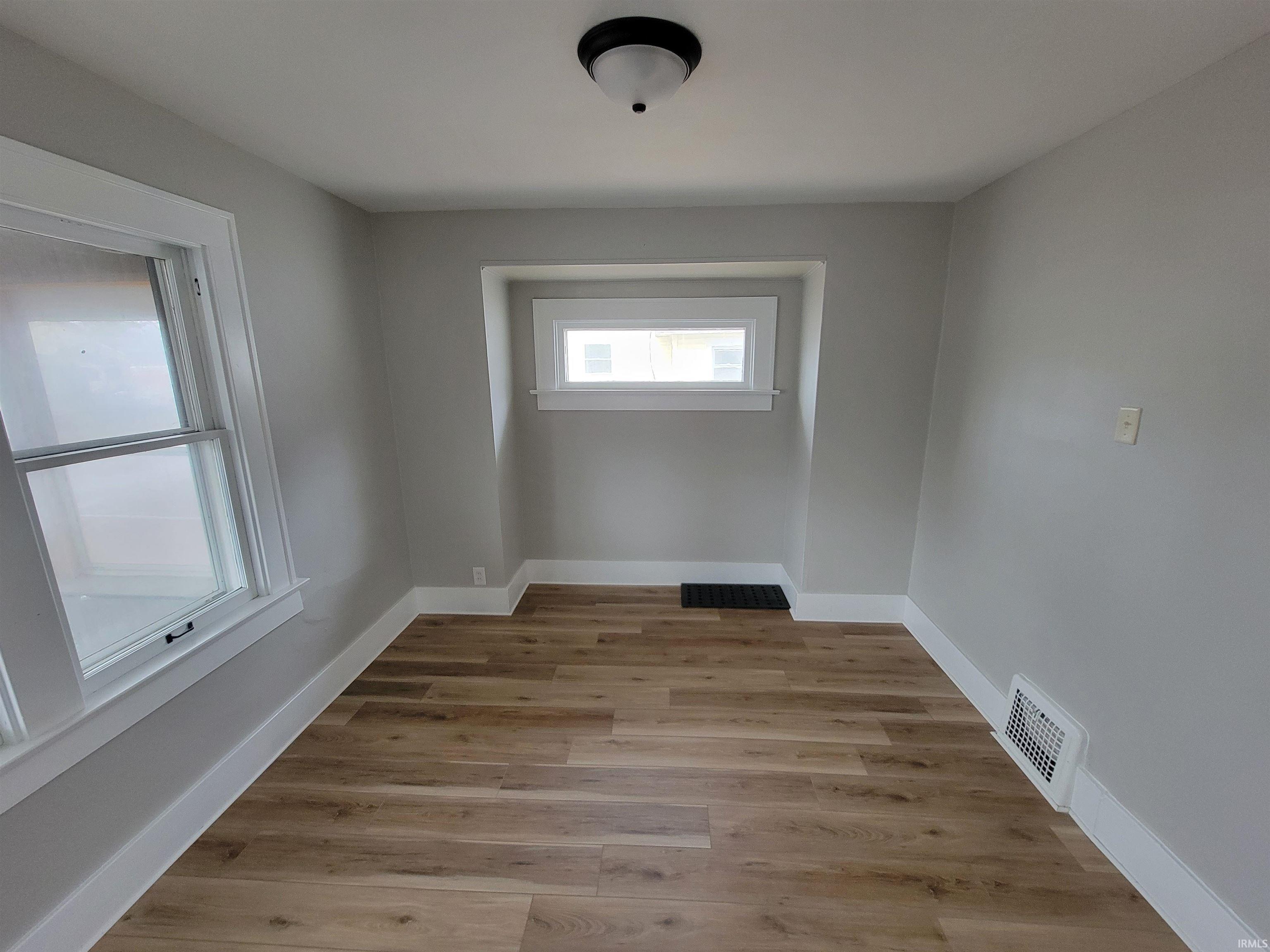 Empty room with baseboards and light wood finished floors