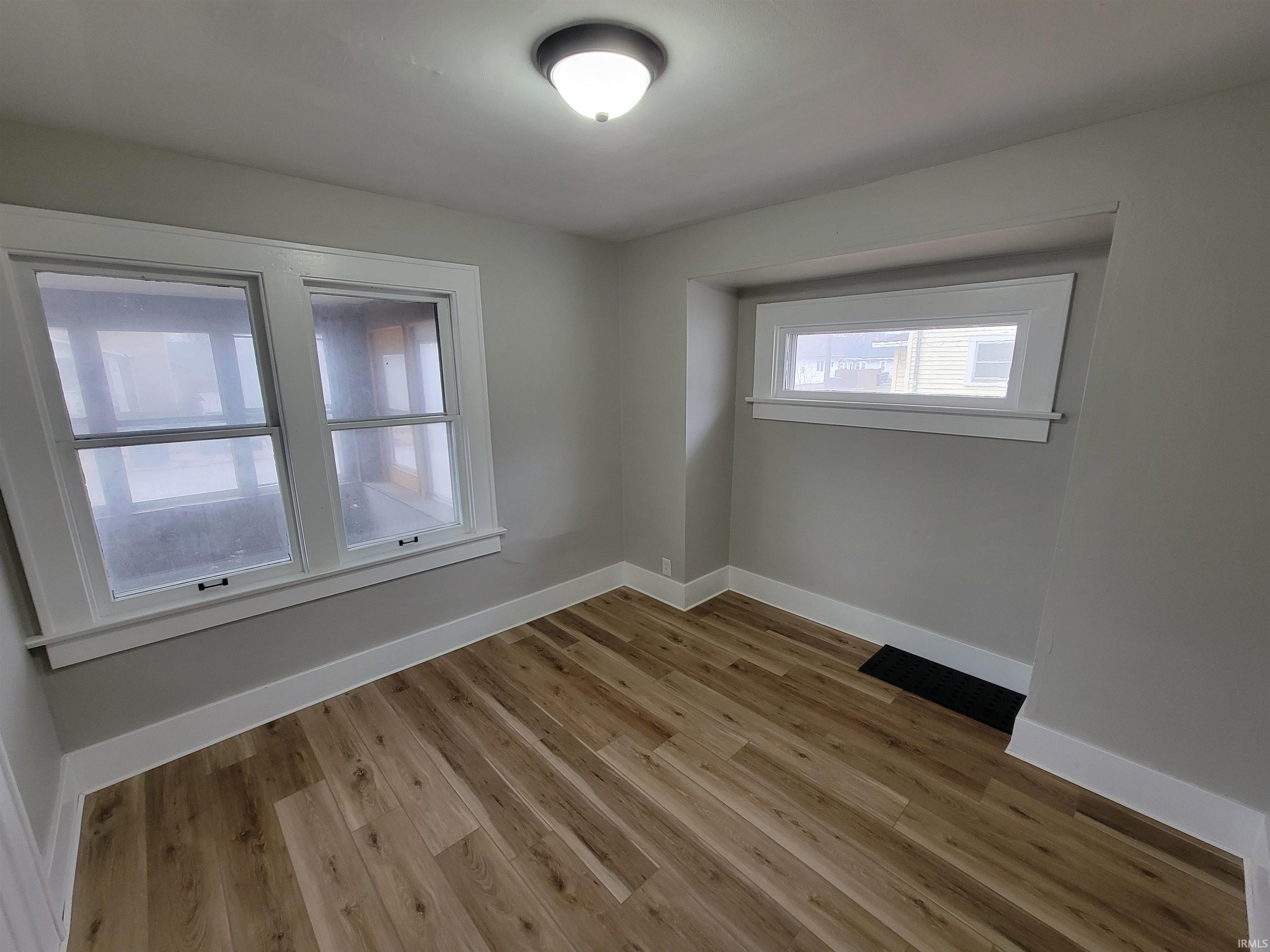 Unfurnished room featuring light wood-type flooring and baseboards