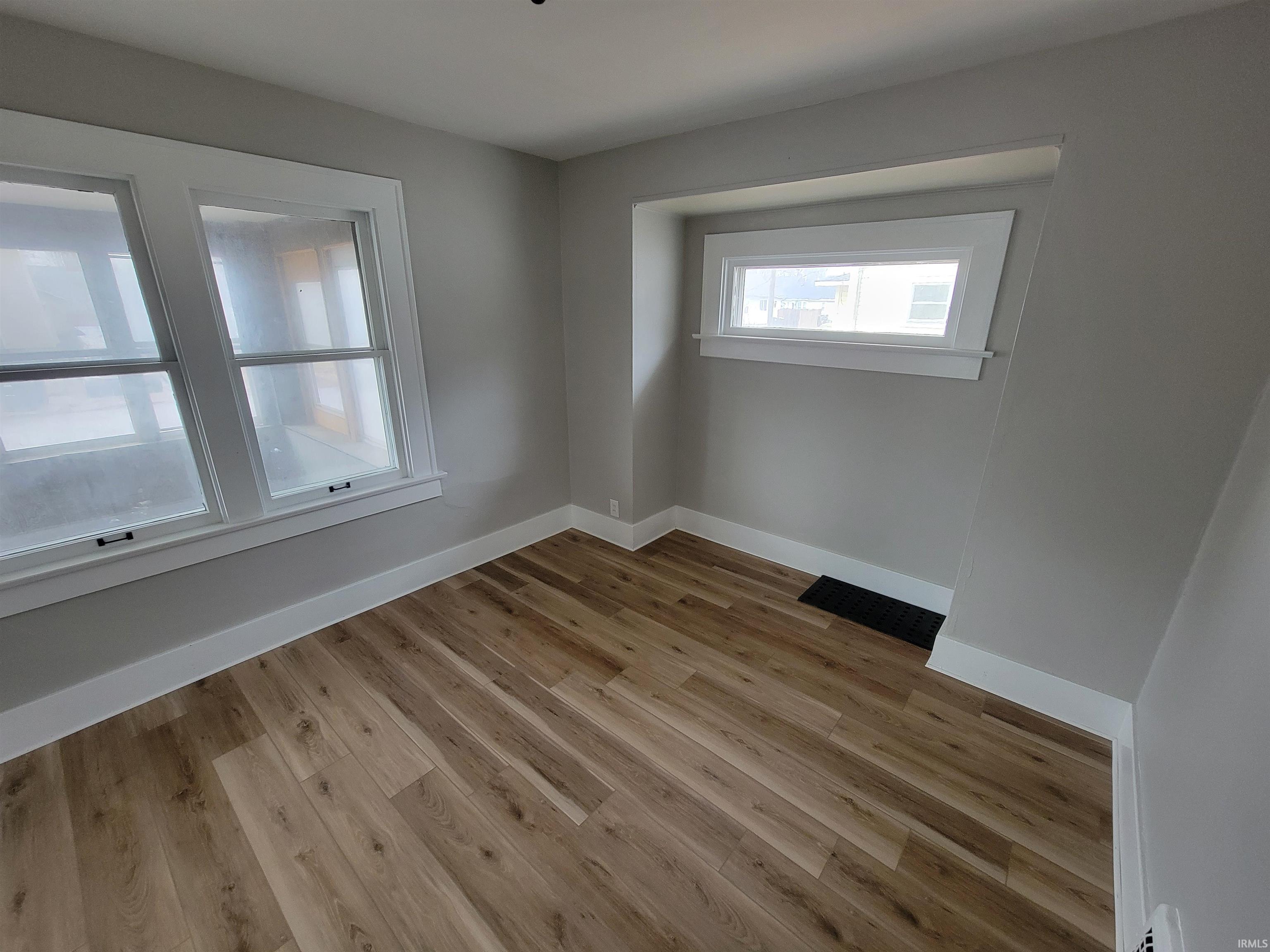 Unfurnished room with light wood-style flooring and baseboards