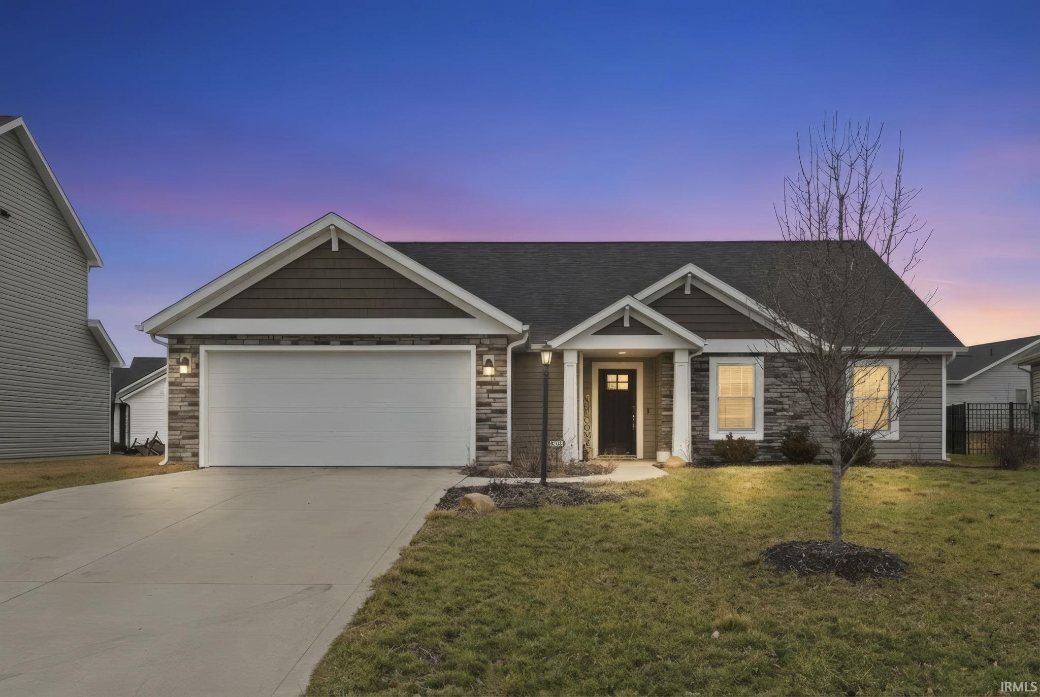 Craftsman inspired home with stone siding, driveway, an attached garage, and a yard