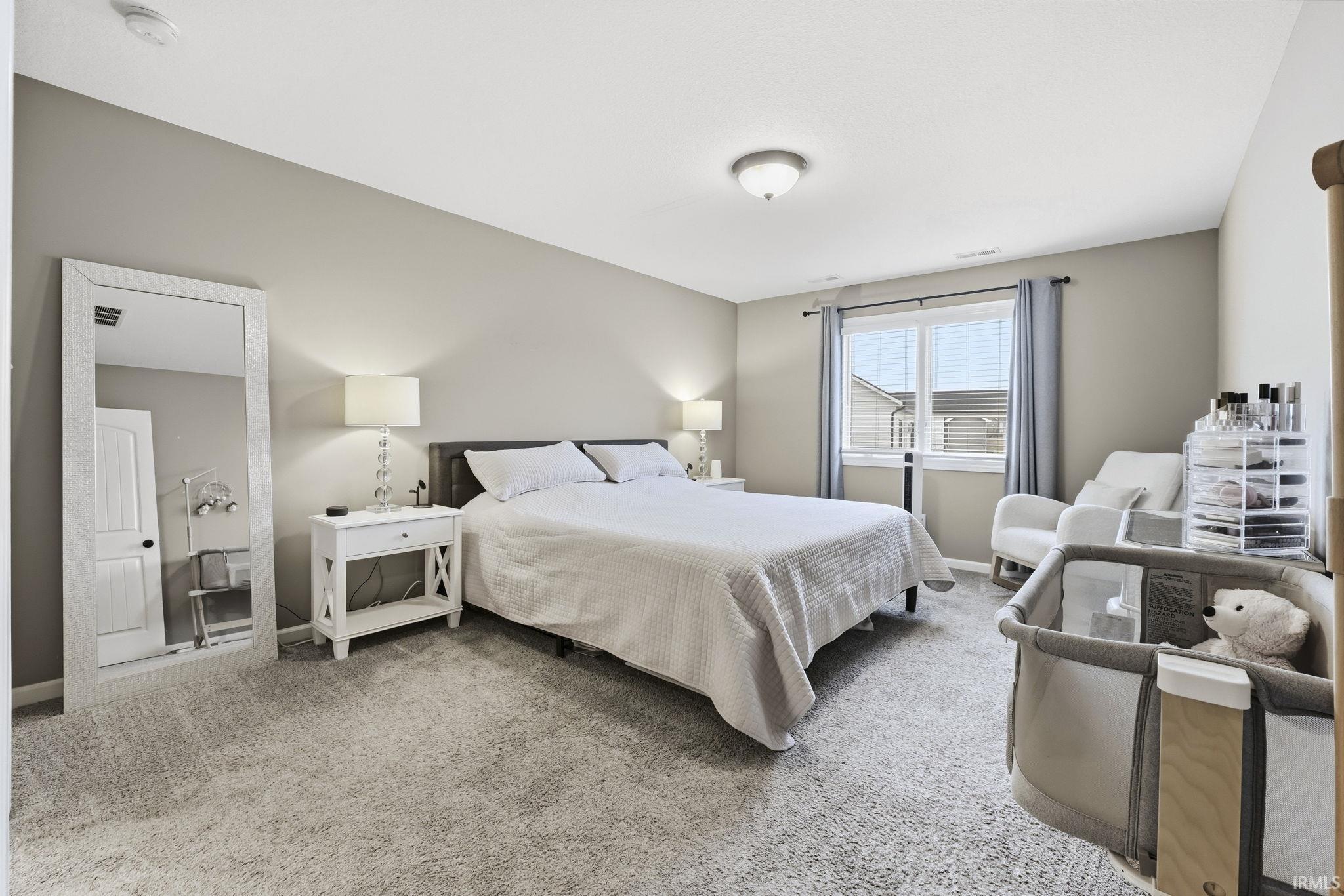 Bedroom with light colored carpet and baseboards